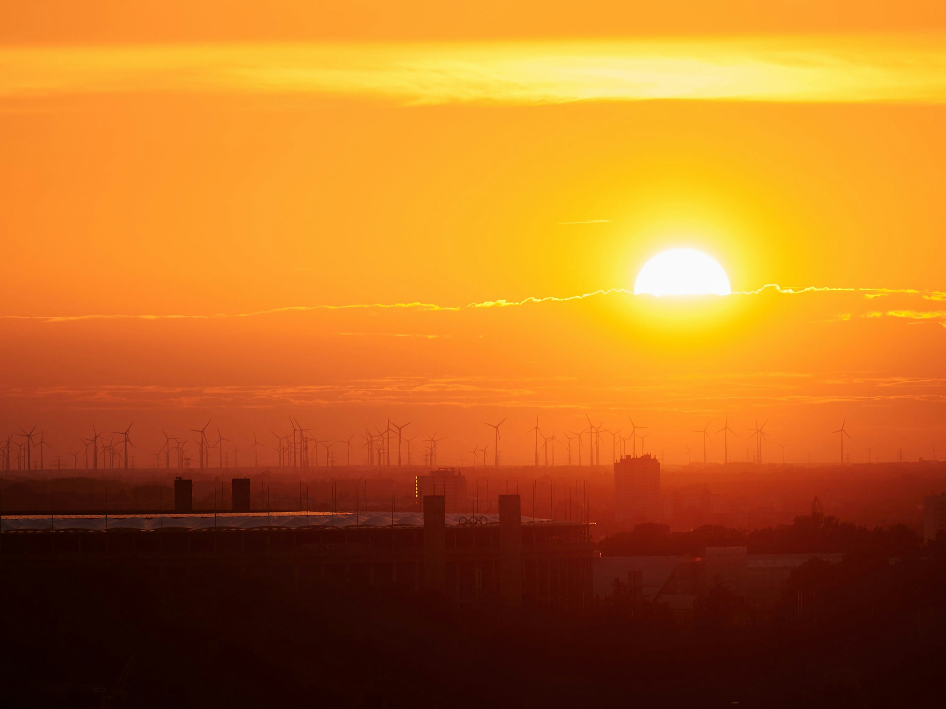Download von www.picturedesk.com am 26.08.2022 (11:40).  22 August 2022, Berlin: From the rbb roof lounge, you can see the setting sun over wind turbines. Photo: Annette Riedl/dpa - 20220822_PD5146 - Rechteinfo: Rights Managed (RM)