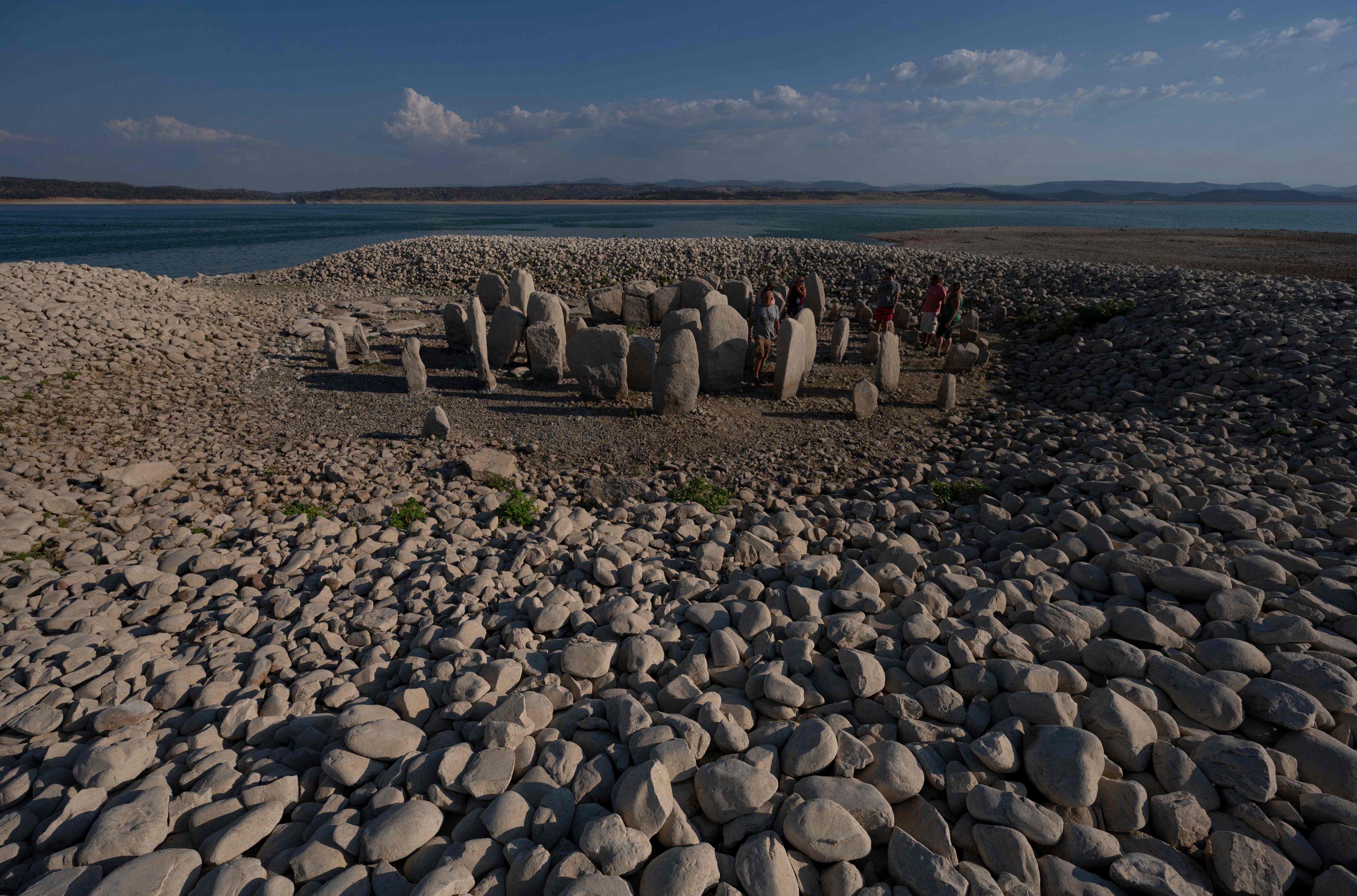 Download von www.picturedesk.com am 27.08.2022 (12:04).  Tourists visit the Dolmen of Guadalperal megalithic site as it is now fully emerged after waters in the surrounding Valdecanas reservoir receded due to the drought hitting Spain, in Peraleda de la Mata on August 25, 2022. - The Dolmen of Guadalperal, dubbed the Spanish Stonehenge, is believed to date back to 5000 BC and was discovered by German archaeologist Hugo Obermaier in 1926. In 1963 the area was flooded in a rural development project but the current drought conditions have allowed these prehistoric standing stones circles to be fully exposed again. (Photo by PIERRE-PHILIPPE MARCOU / AFP) - 20220825_PD14032 - Rechteinfo: Rights Managed (RM) Nur für redaktionelle Nutzung! Werbliche Nutzung erfordert Freigabe: bitte schicken Sie uns eine Anfrage.
