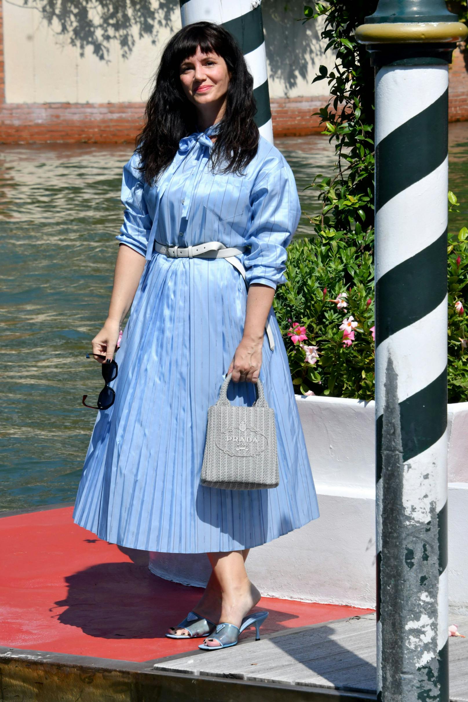 Die argentinische Schauspielerin Griselda Siciliani ist in Venedig angekommen. Passend zu ihrem blauen Kleid trägt sie Tasche und Schuhe von Prada.