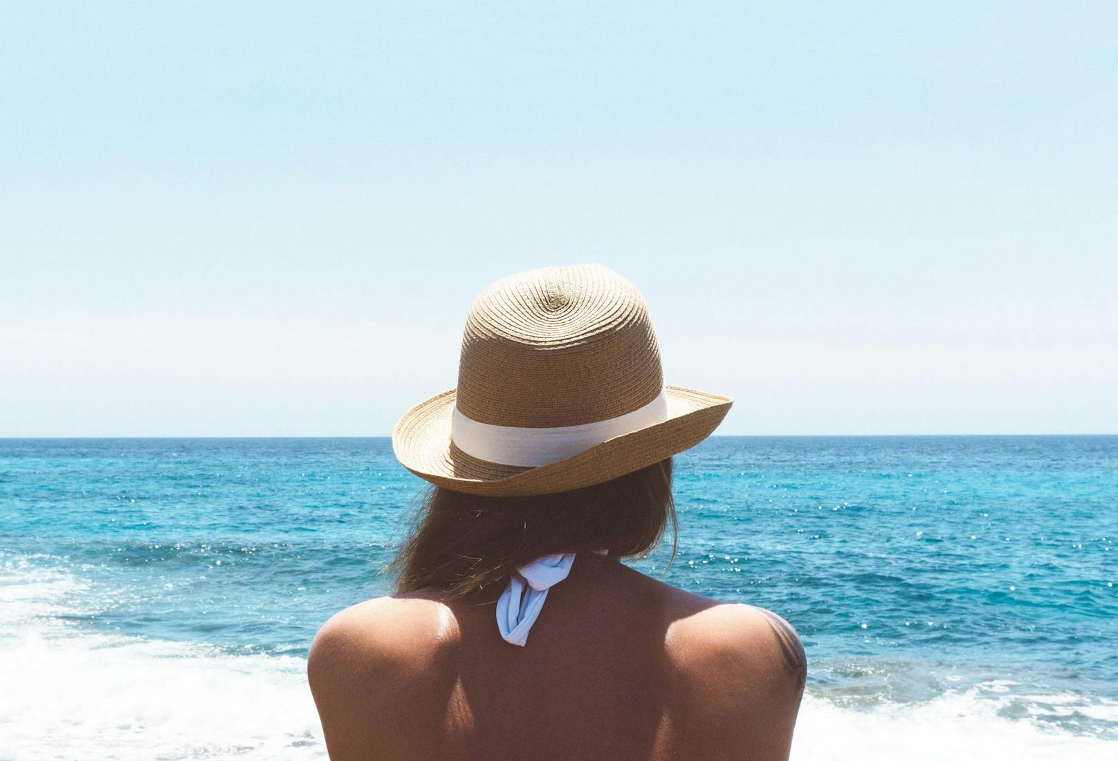 Kopfbedeckung wie ein Hut gehört zu einem Tag am Strand: Besonders breitkrempige Hüte schützen vor der Sonne und wirken gleichzeitig elegant.