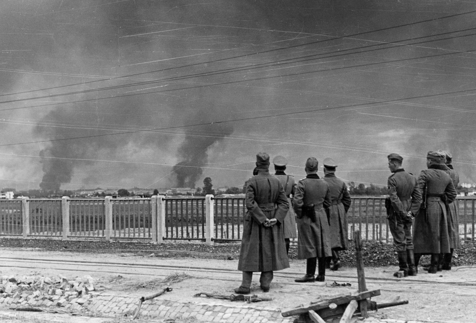 Deutsche Militärs beobachten das brennende Warschau aus der Ferne.