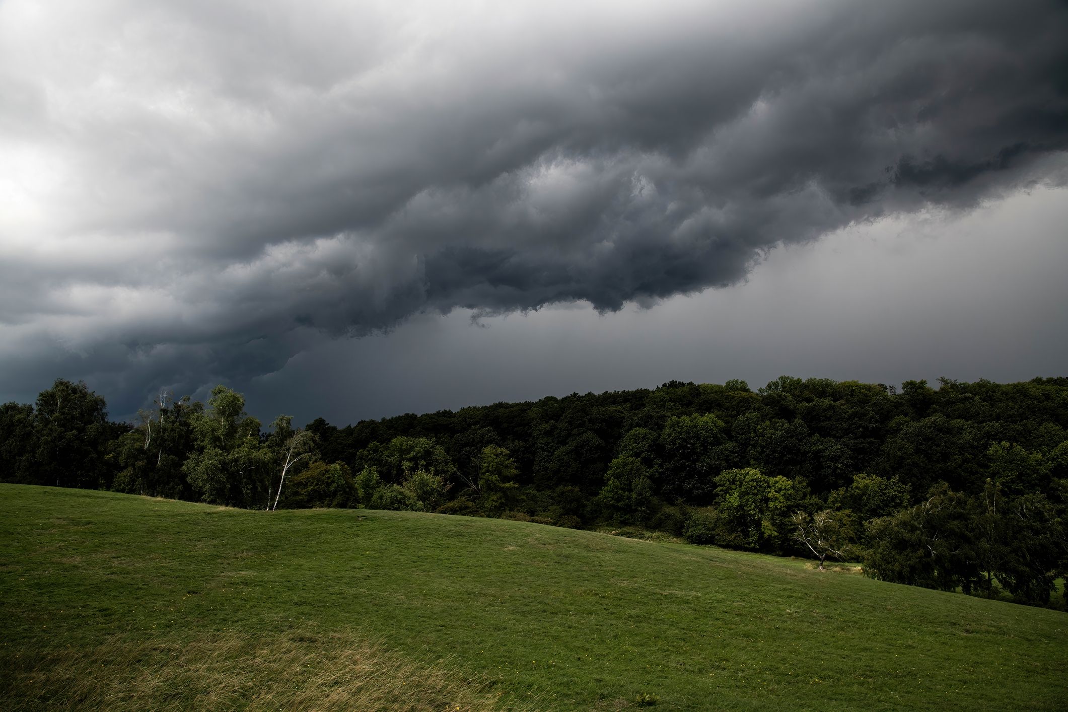 Gewitterwolken über einem Hügel. Symbolbild