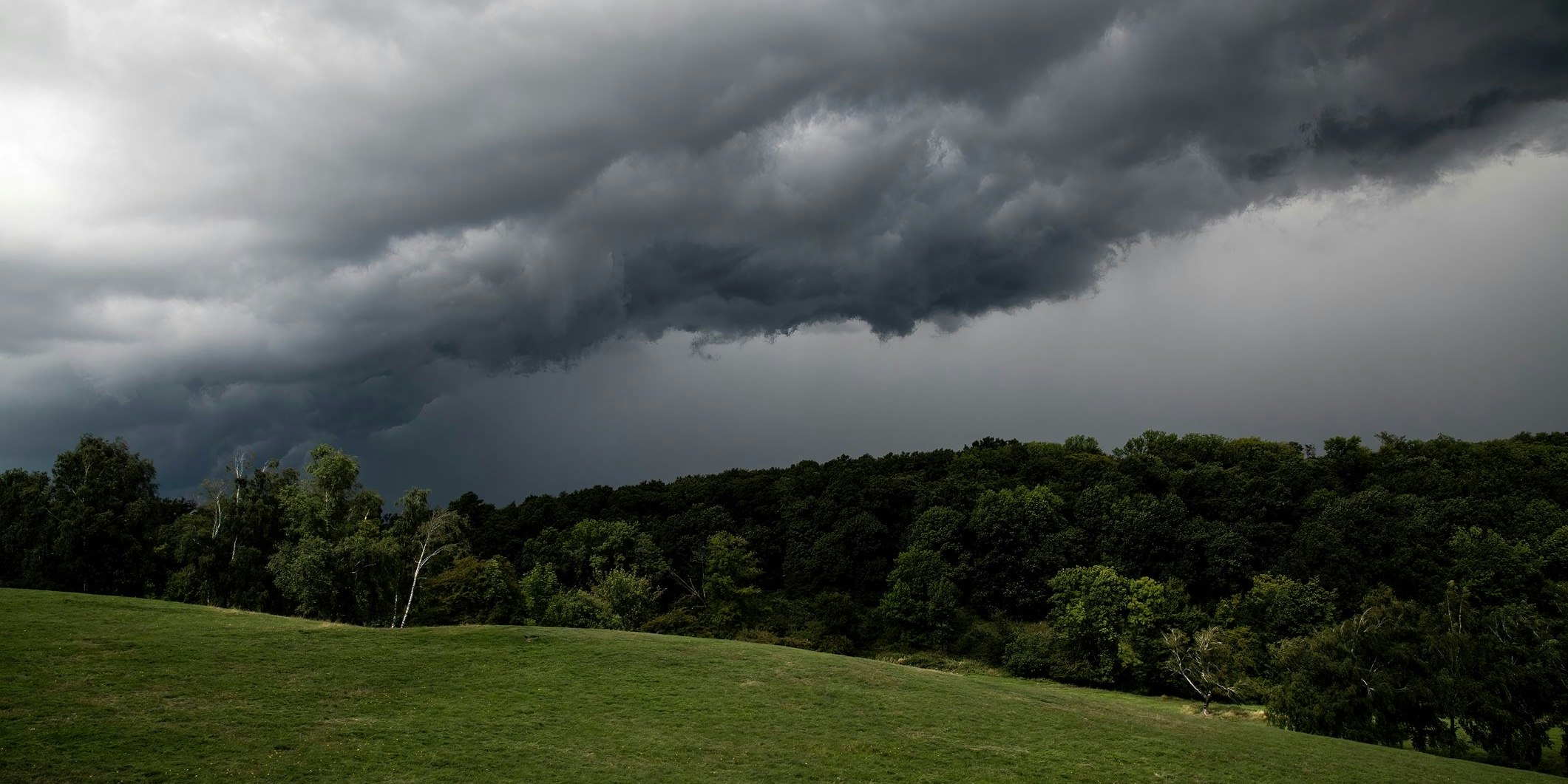 Gewitterwolken über einem Hügel. Symbolbild