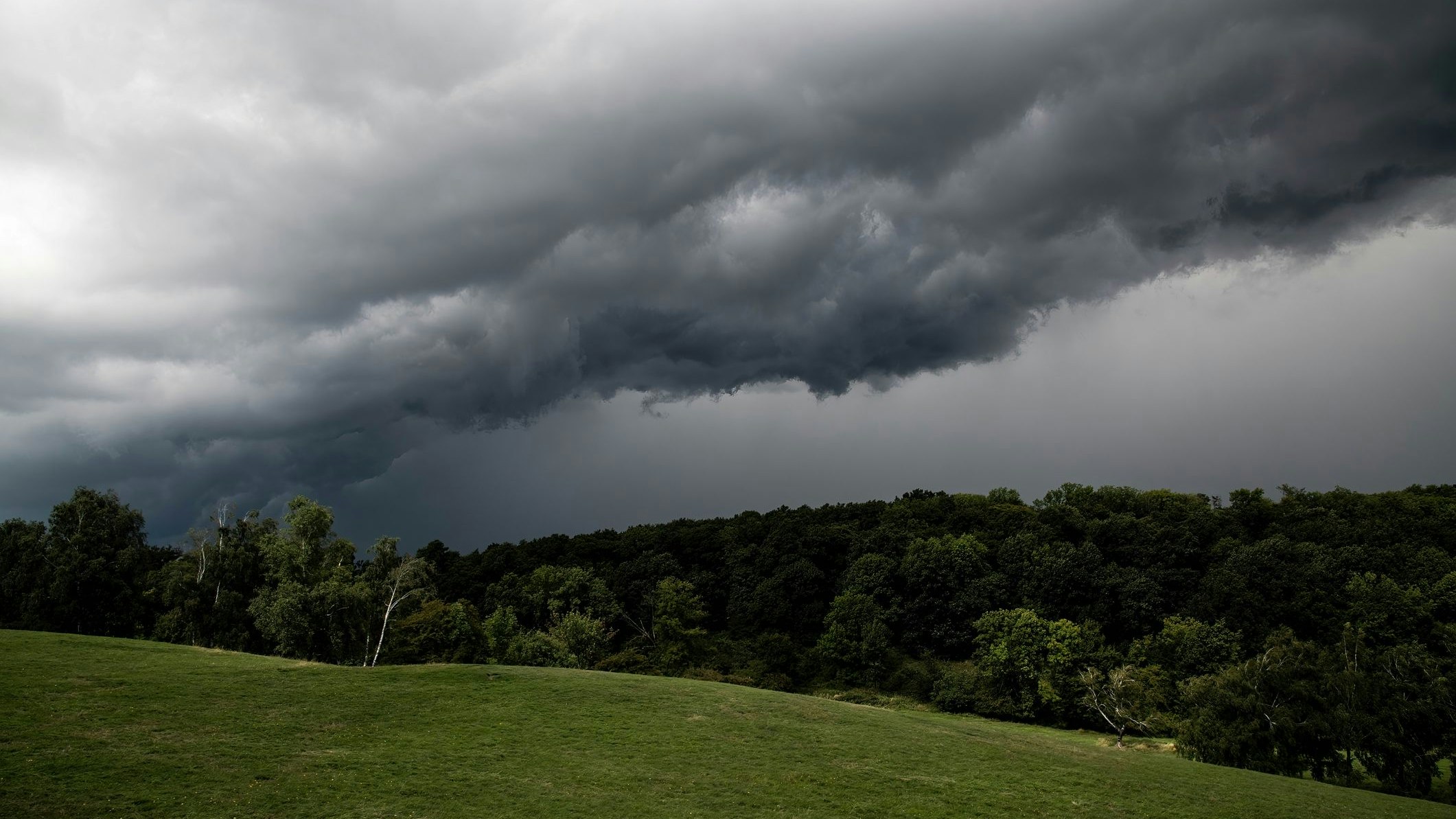 Gewitterwolken über einem Hügel. Symbolbild