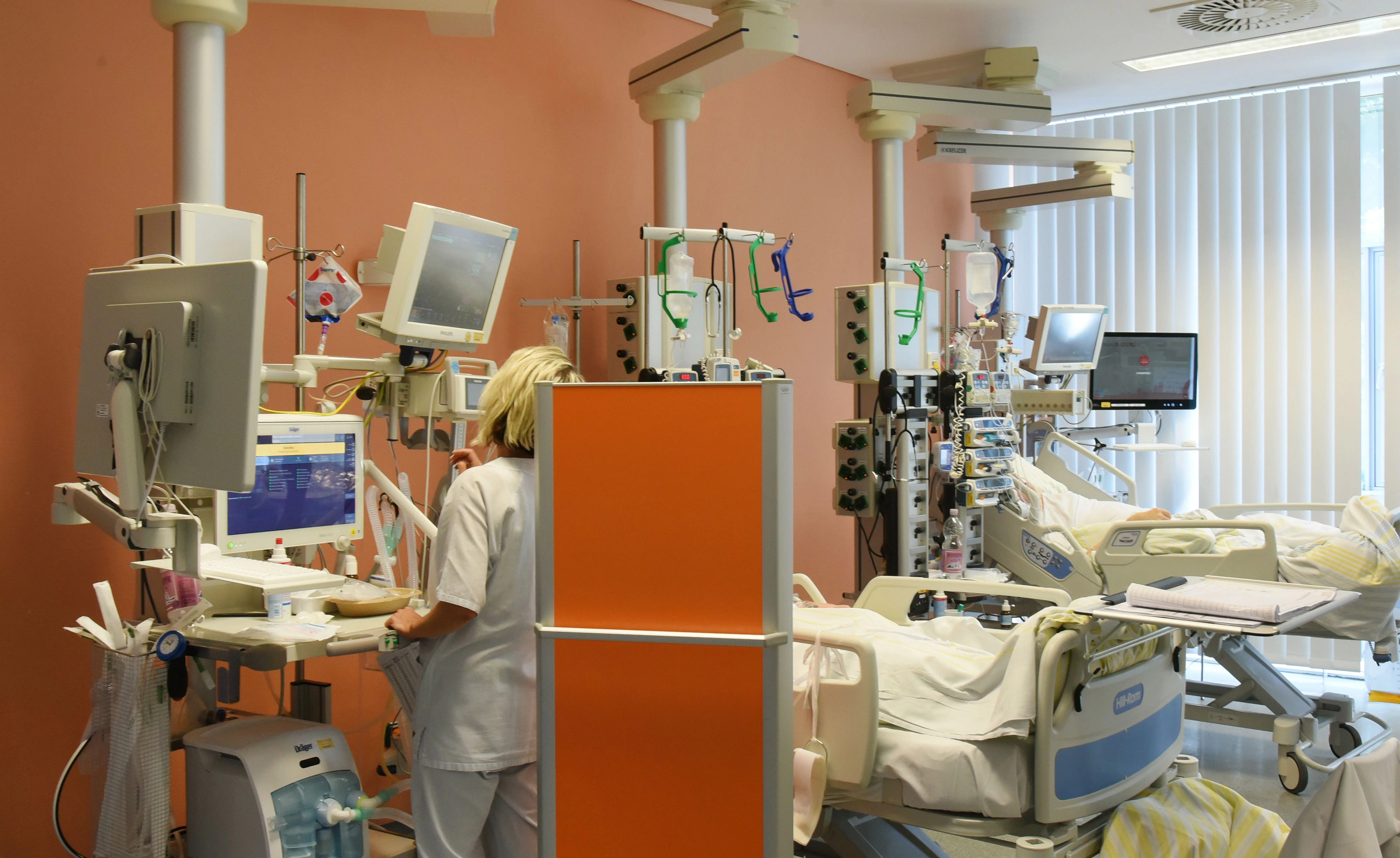 Download von www.picturedesk.com am 08.09.2022 (10:16).  30 June 2022, Saxony, Leipzig: Intensive care nurse and deputy director Daniela Weigel stands at the bedside of a patient in the intensive care unit (ITS) at Klinikum St. Georg. Compared to the pre-Corona era, the hospital currently operates about a quarter fewer beds. The reason is a lack of personnel and the introduction of lower limits for nursing staff, said a spokeswoman. In addition, there are repeated absences due to staff suffering from covid. Especially in the intensive care areas and during operations, the shortage affects the ability to act. (to dpa "Situation in Saxon hospitals is tense") Photo: Waltraud Grubitzsch/dpa-Zentralbild/dpa - 20220630_PD17456 - Rechteinfo: Rights Managed (RM)