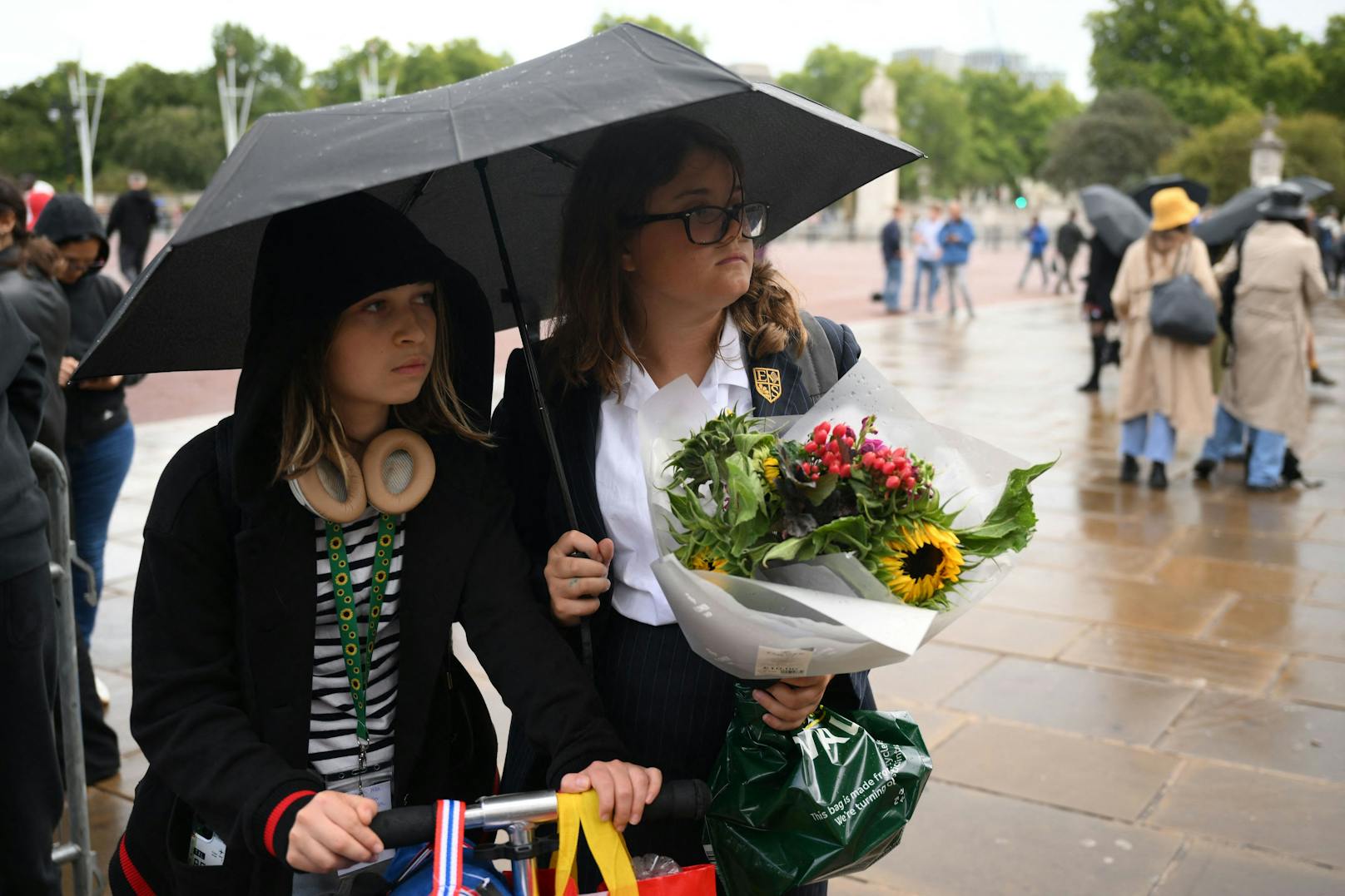 Britische Bürger bringen Blumen zum Buckingham Palace.