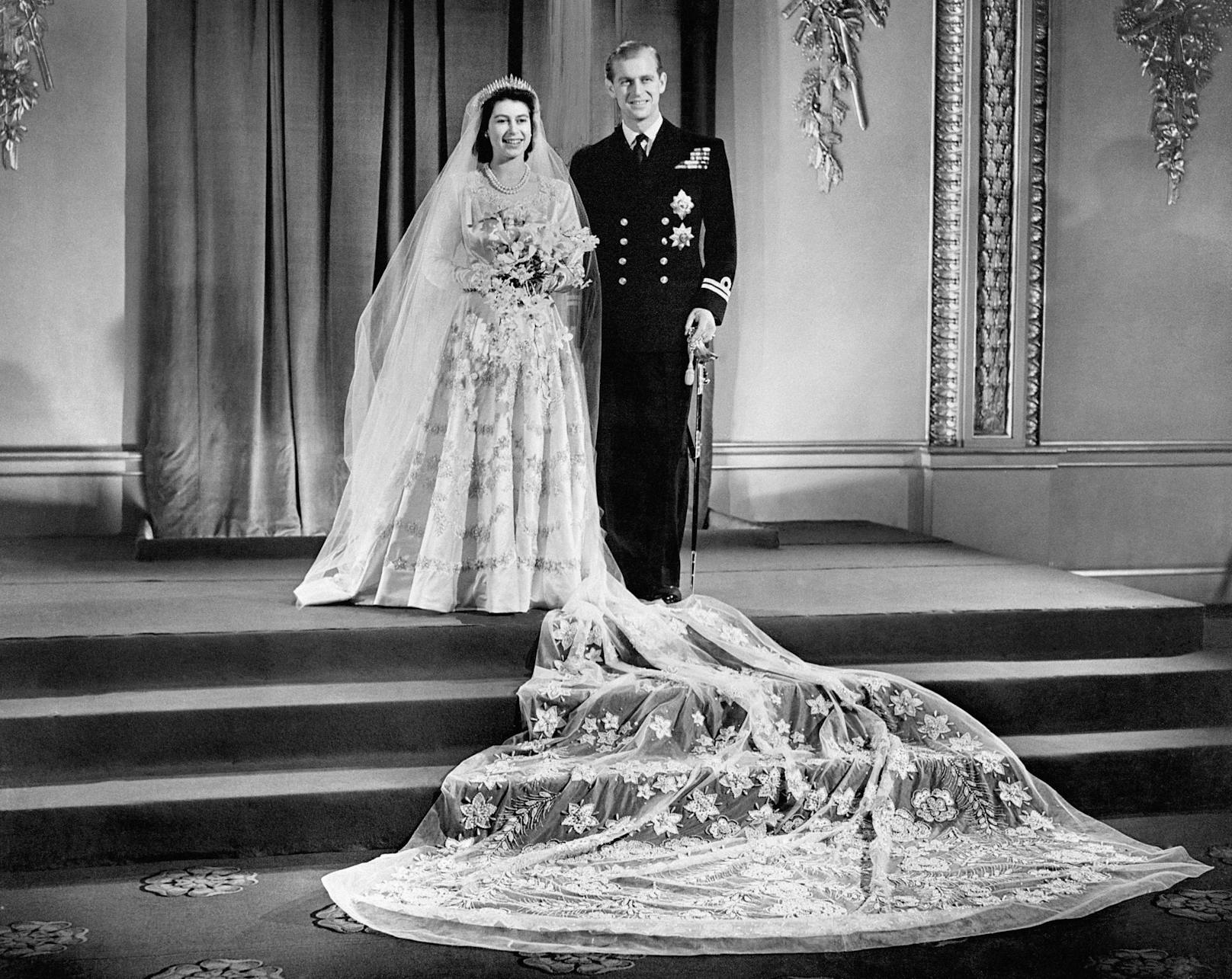 Ihr Hochzeitskleid von einem der damals bekanntesten Designer,&nbsp;Norman Hartnell, wurde von 350 Frauen genäht und bestickt. Diese arbeiteten drei Monate daran.