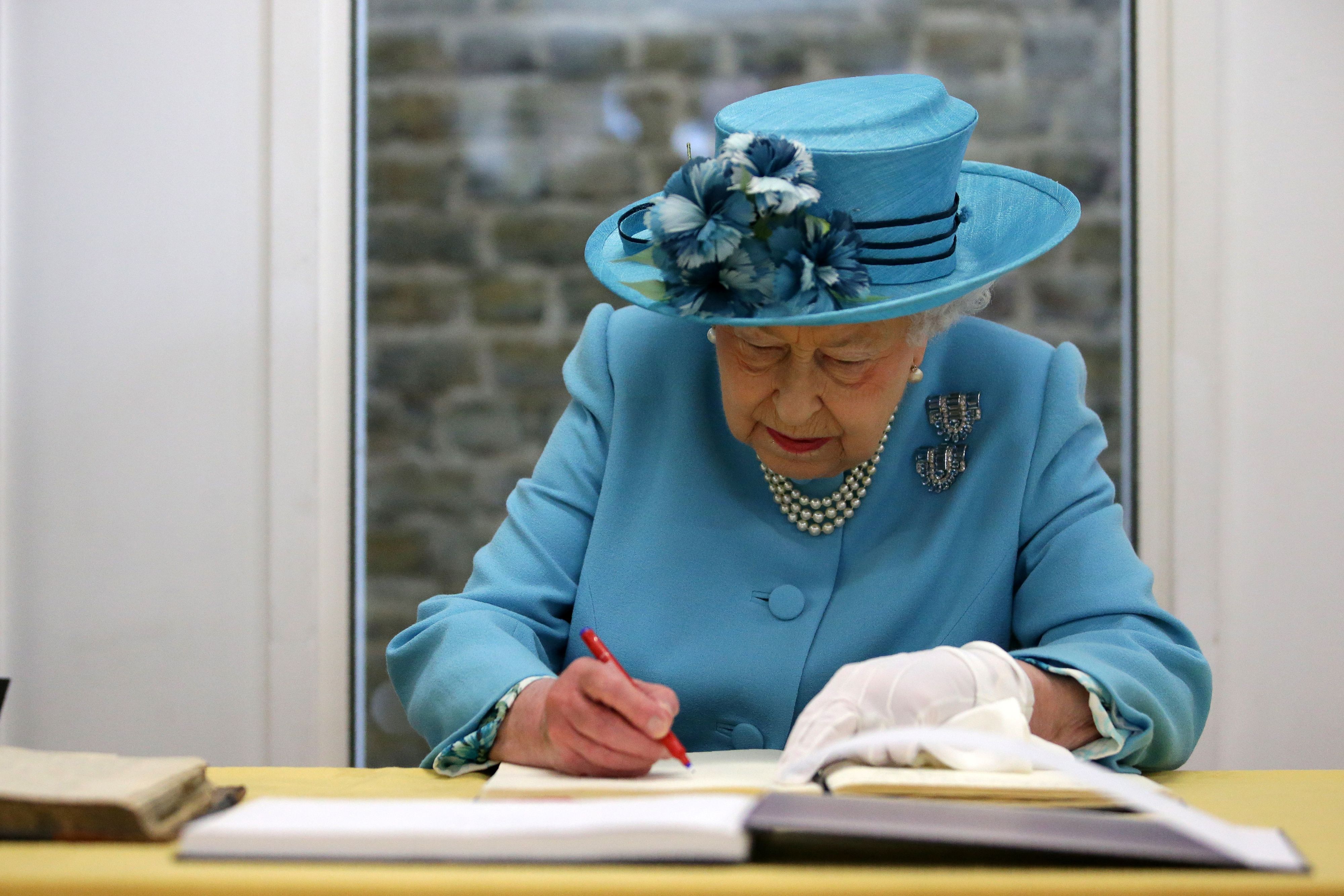 Britain's Queen Elizabeth signs the visitos book at the Mayflower Primary School during a visit to Poplar in Tower Hamlets in East London, Britain June 15, 2017.  REUTERS/Daniel Leal-Olivas/Pool