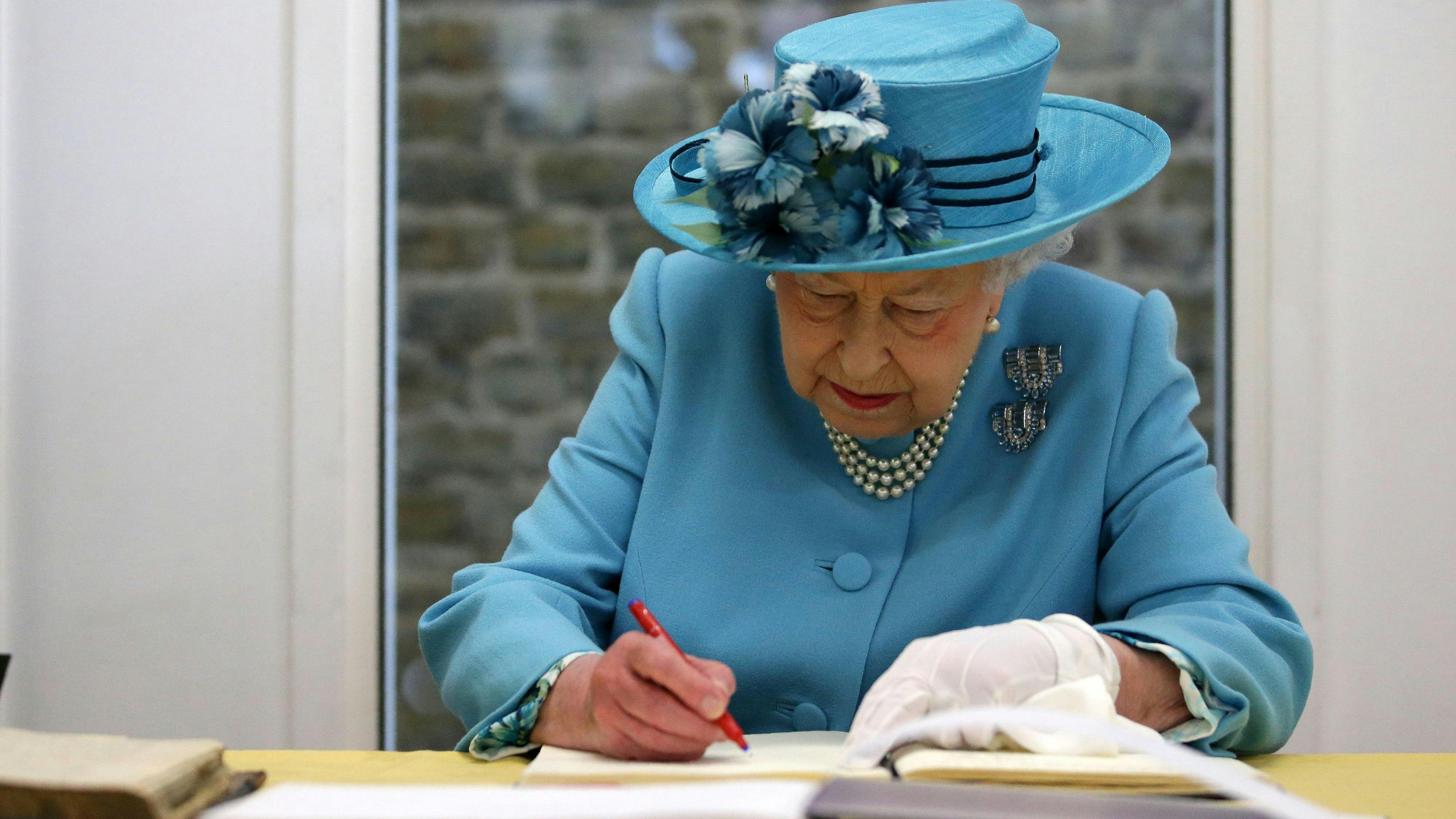 Britain's Queen Elizabeth signs the visitos book at the Mayflower Primary School during a visit to Poplar in Tower Hamlets in East London, Britain June 15, 2017.  REUTERS/Daniel Leal-Olivas/Pool