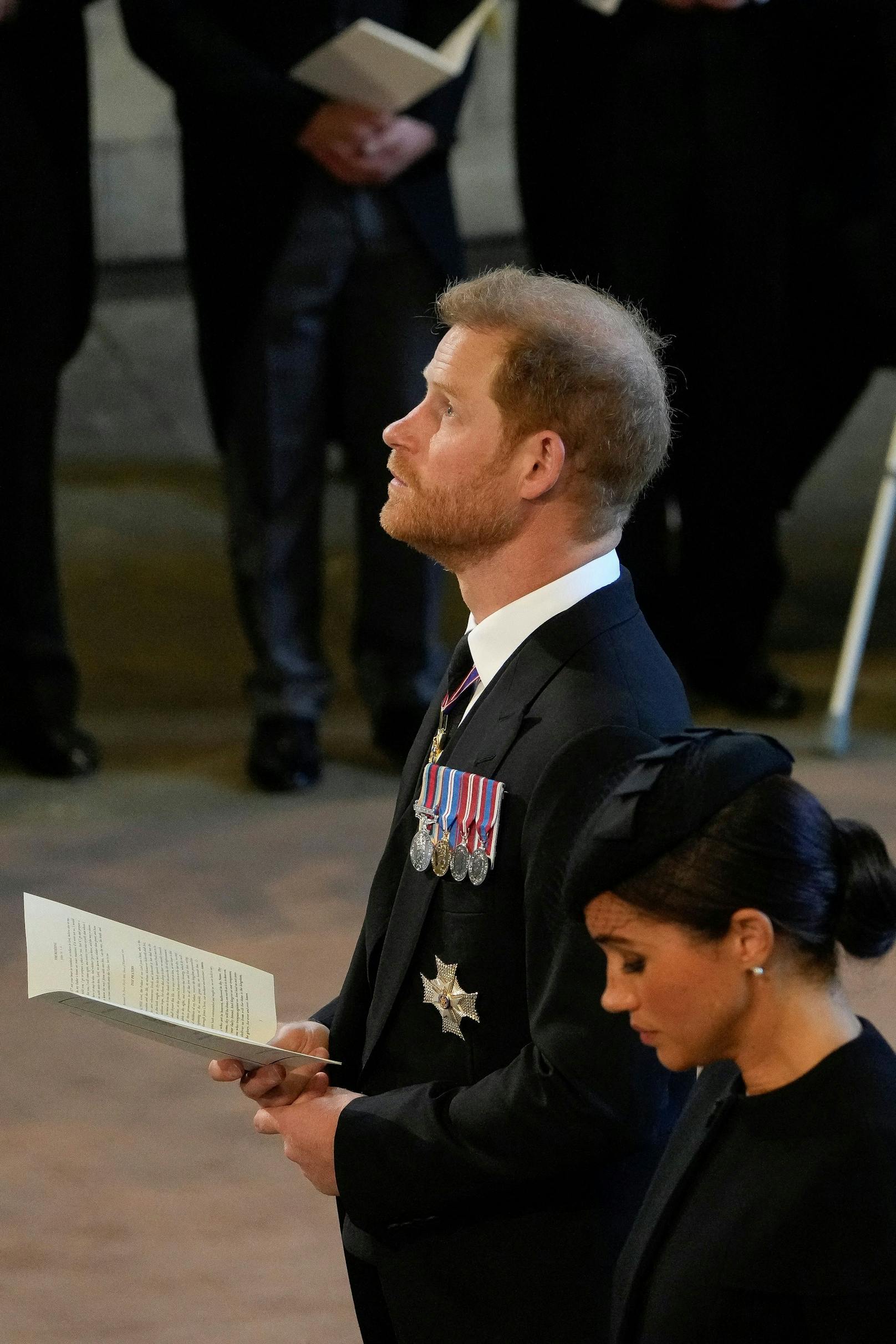 Der britische Prinz Harry, links, und Meghan, Herzogin von Sussex, stehen in der Westminster Hall, nachdem sie an der Prozession des Sarges von Queen Elizabeth, London, Mittwoch, den 14. September 2022, teilgenommen haben.