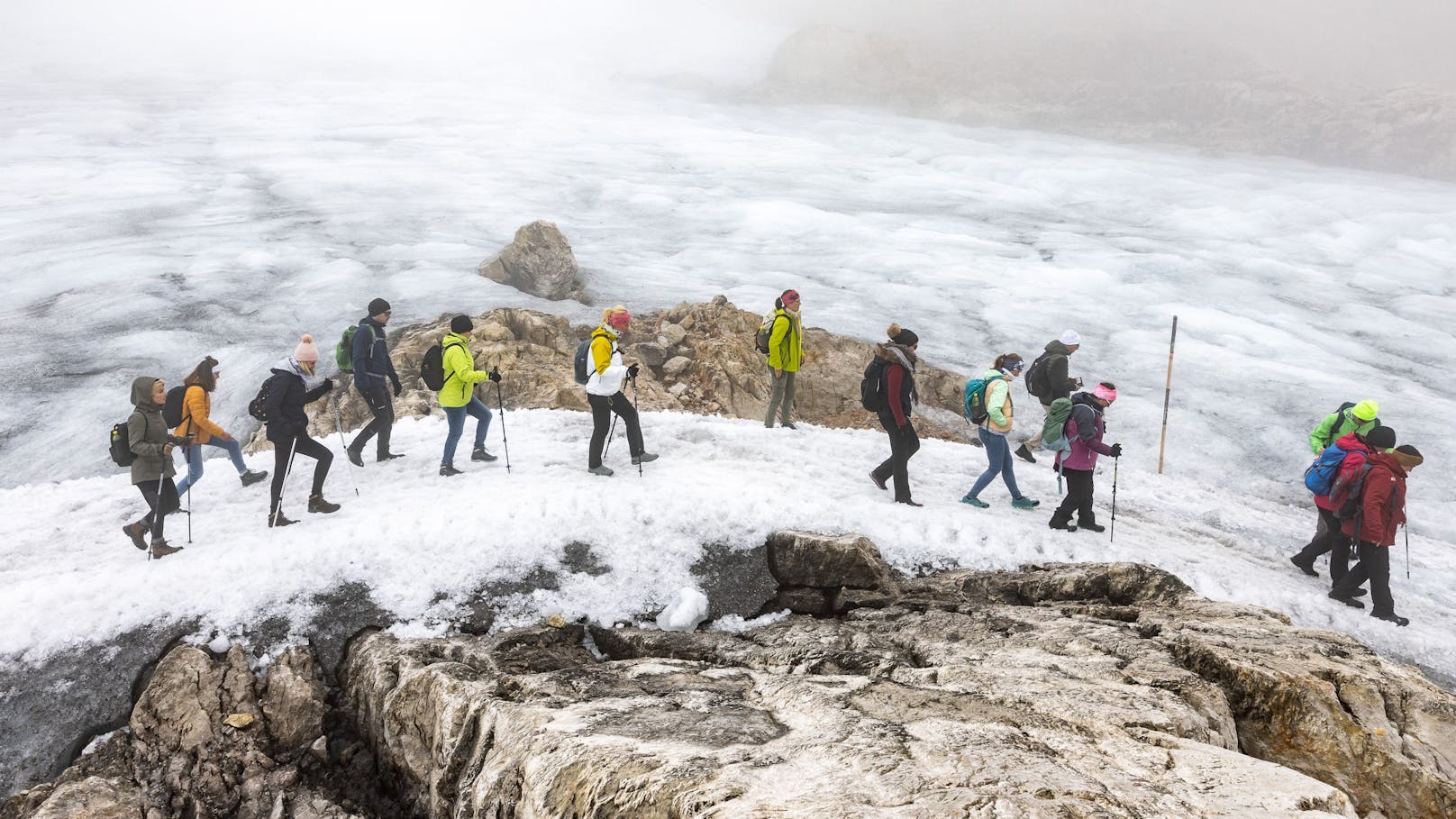 Wanderer am Übergang zwischen Schladminger Gletscher und Hallstätter Gletscher, der aufgrund der warmen Temperaturen im Sommer 2022 beinahe schneefrei geworden ist.