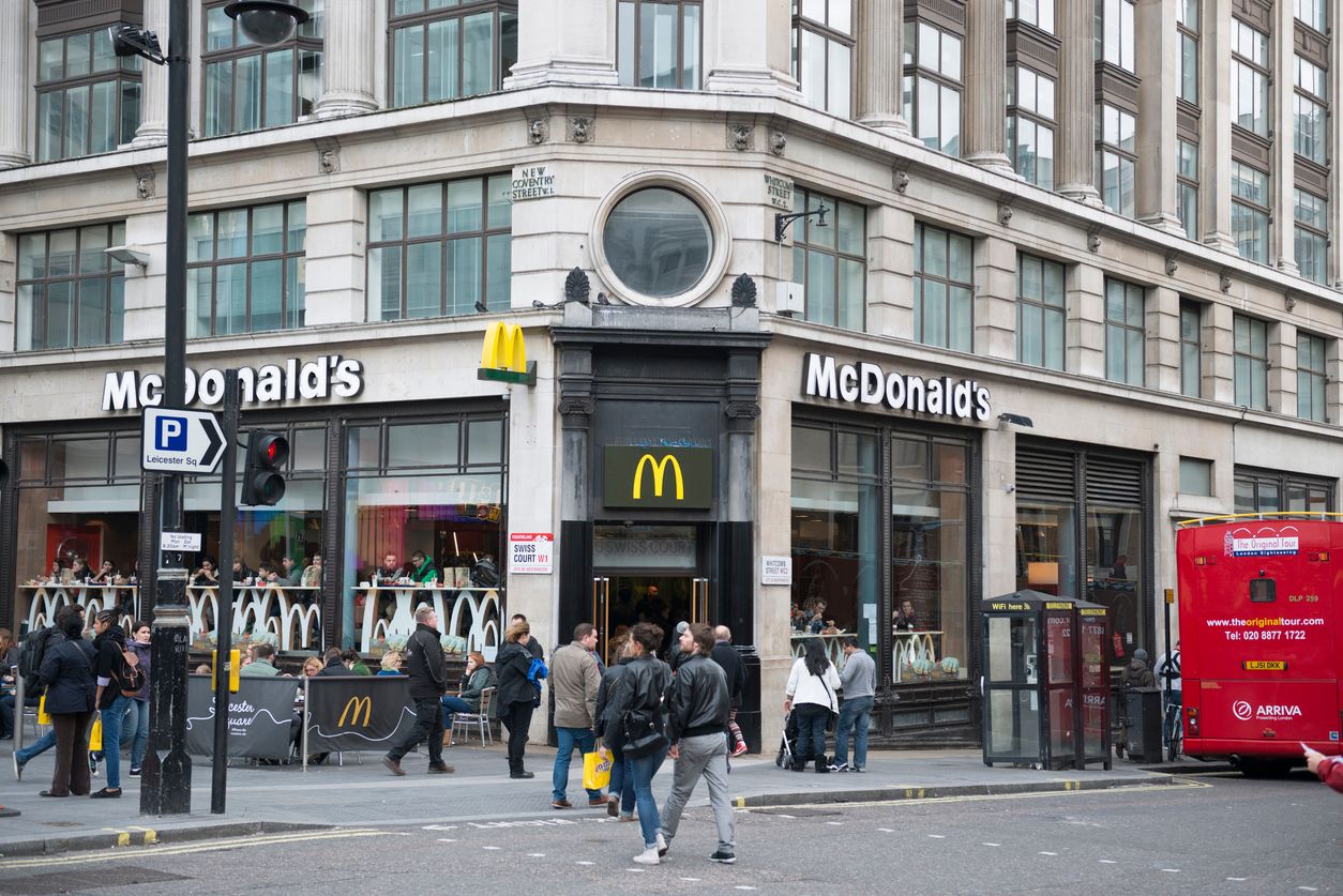 London, UK - October 27, 2013: People walking past and into McDonalds restaurant on the edge of Leicester Square, London on a late Autumn day.