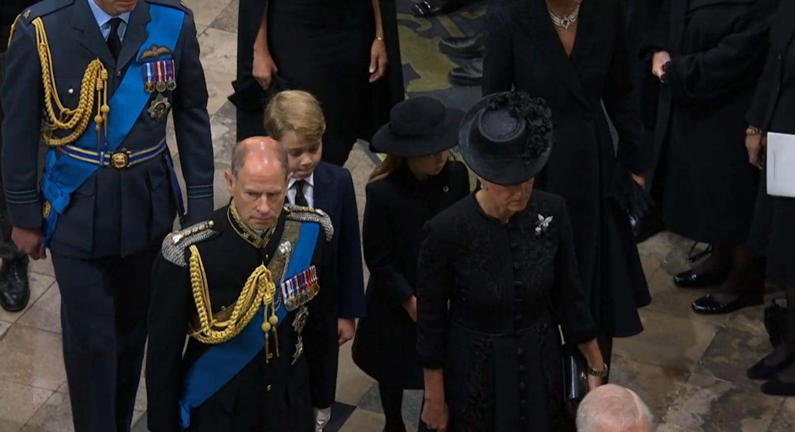 Danach kommt Prinz Edward, der jüngste Sohn der Queen und seine Frau Sophie. Dahinter gehen William mit seinen Kindern und Prinzessin Kate.