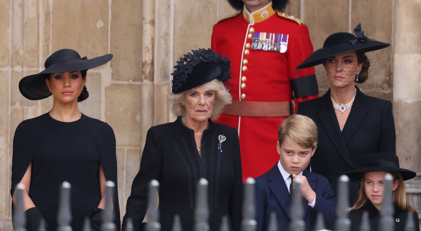 Herzogin Meghan mit Queen Consort Camilla und Prinzessin Kate und den Kindern Prinz George und Prinzessin Charlotte. Meghan wirkt sichtlich berührt. 