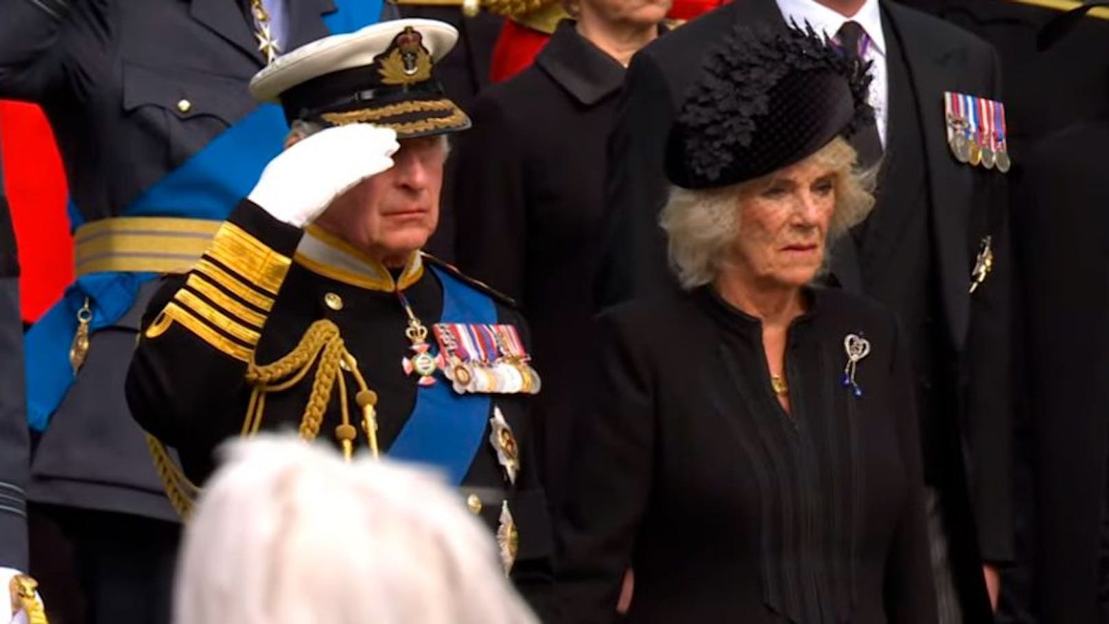 König Charles III. salutierte vor dem Sarg seiner verstorbenen Mutter Queen Elizabeth II. am Wellington Arch in London. Queen Consort Camillas Blick ist wie versteinert.