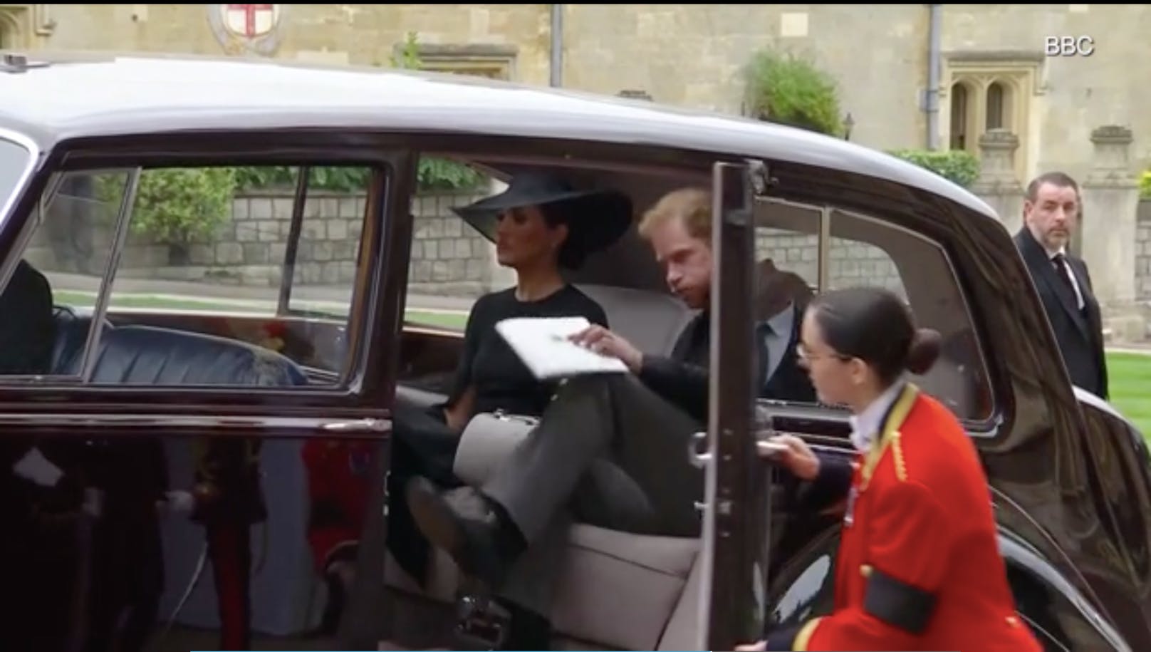 Erschöpft lässt sich Prinz Harry neben Herzogin Meghan ins Auto fallen und atmet dabei tief aus. 