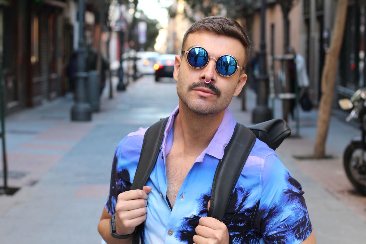 Attractive millennial with nose ring, sunglasses and Hawaiian shirt.