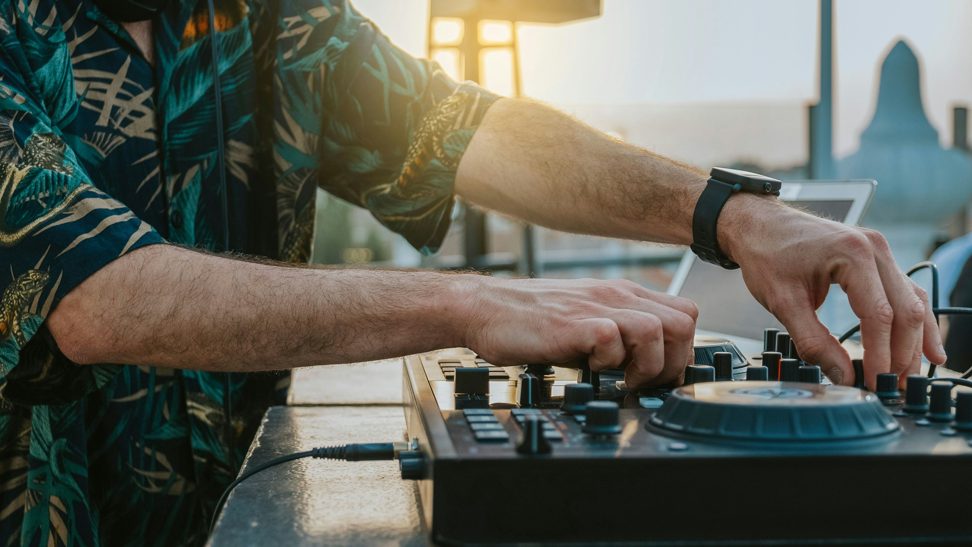 Close-up of the hands of a DJ playing music on a terrace