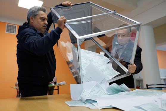 Mitglieder der Wahlkommission in Donezk entleeren eine Wahlurne der russischen Scheinreferenden am 27. September 2022.