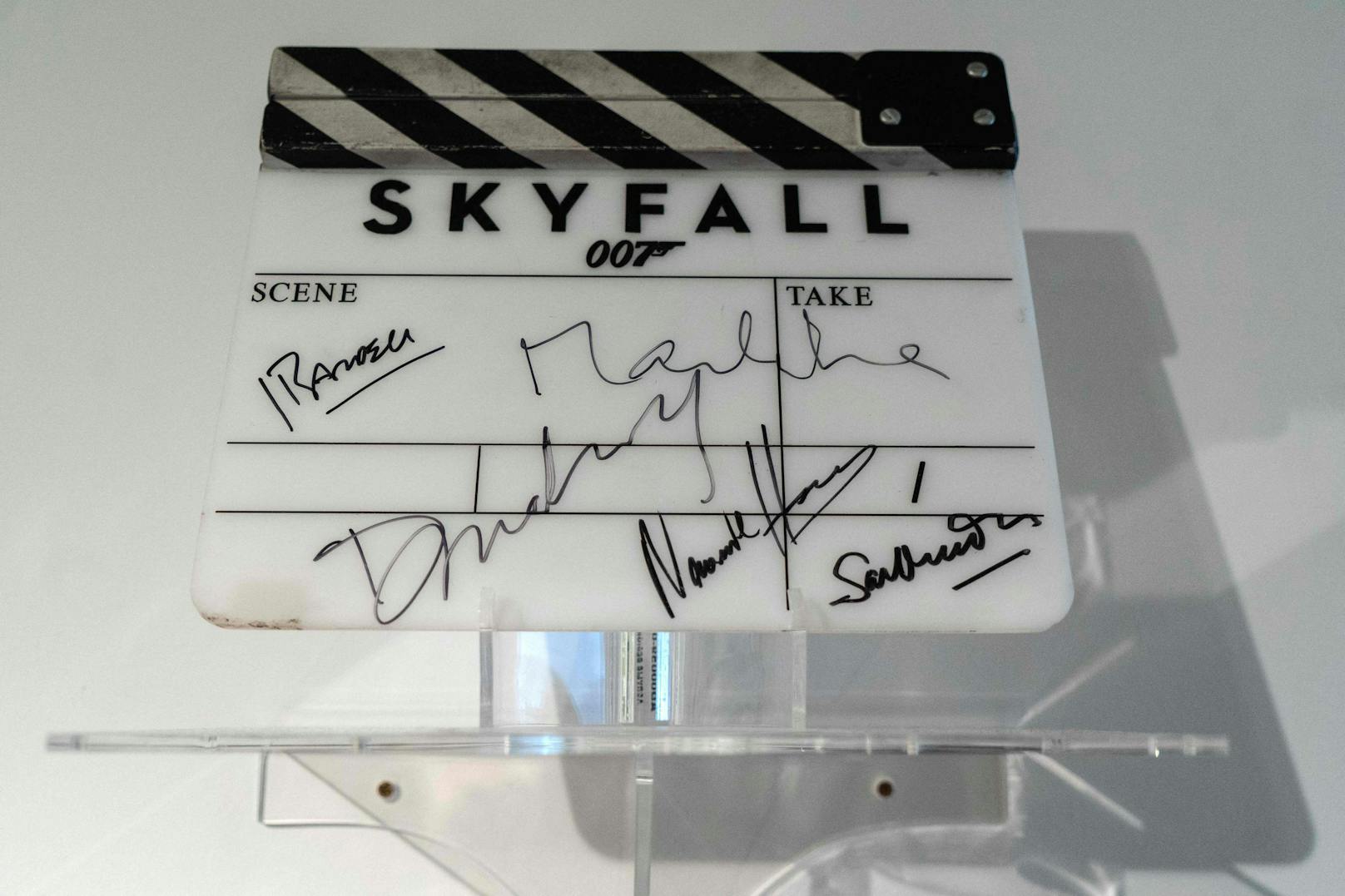 Die Kamera-Klappe aus dem Film "Skyfall" (2008). Signiert vom Hauptdarsteller Daniel Craig sowie von Sam Mendes, dem "Bondgirl" Bérénice Marlohe, Naomie Harris und Javier Bardem.