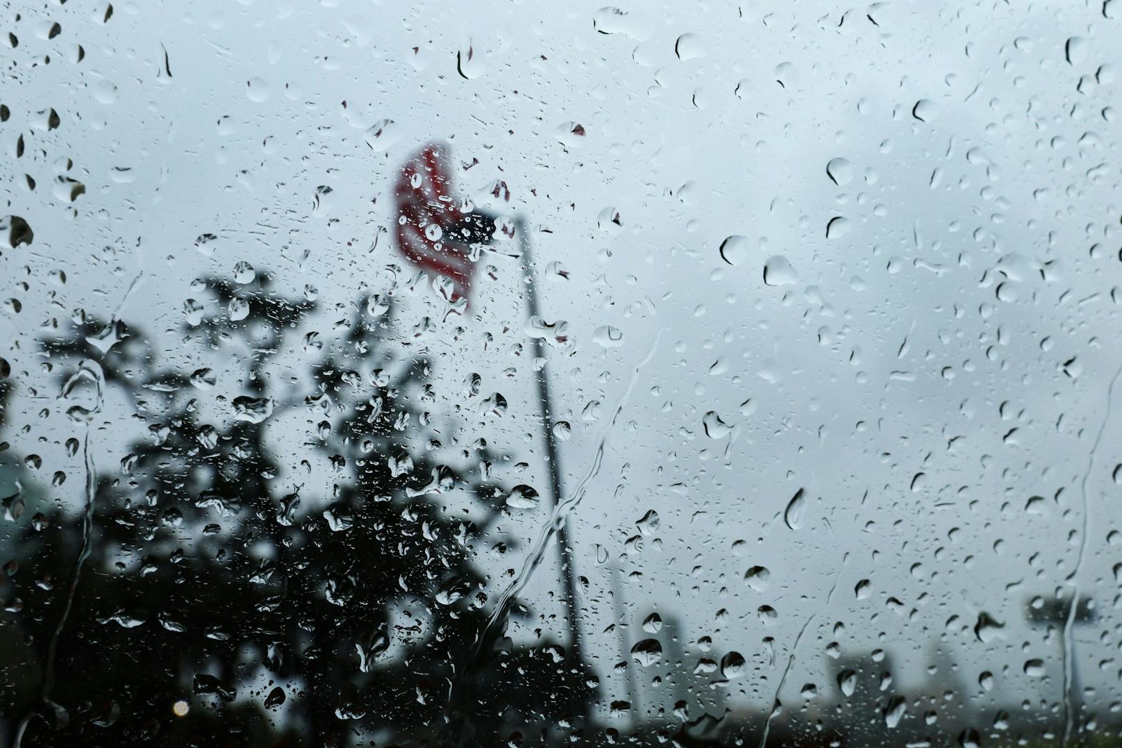 Eine US-Flagge weht im Wind, als sie durch das Fenster eines Autos gesehen wird, während Hurrikan Ian in Florida wütet.