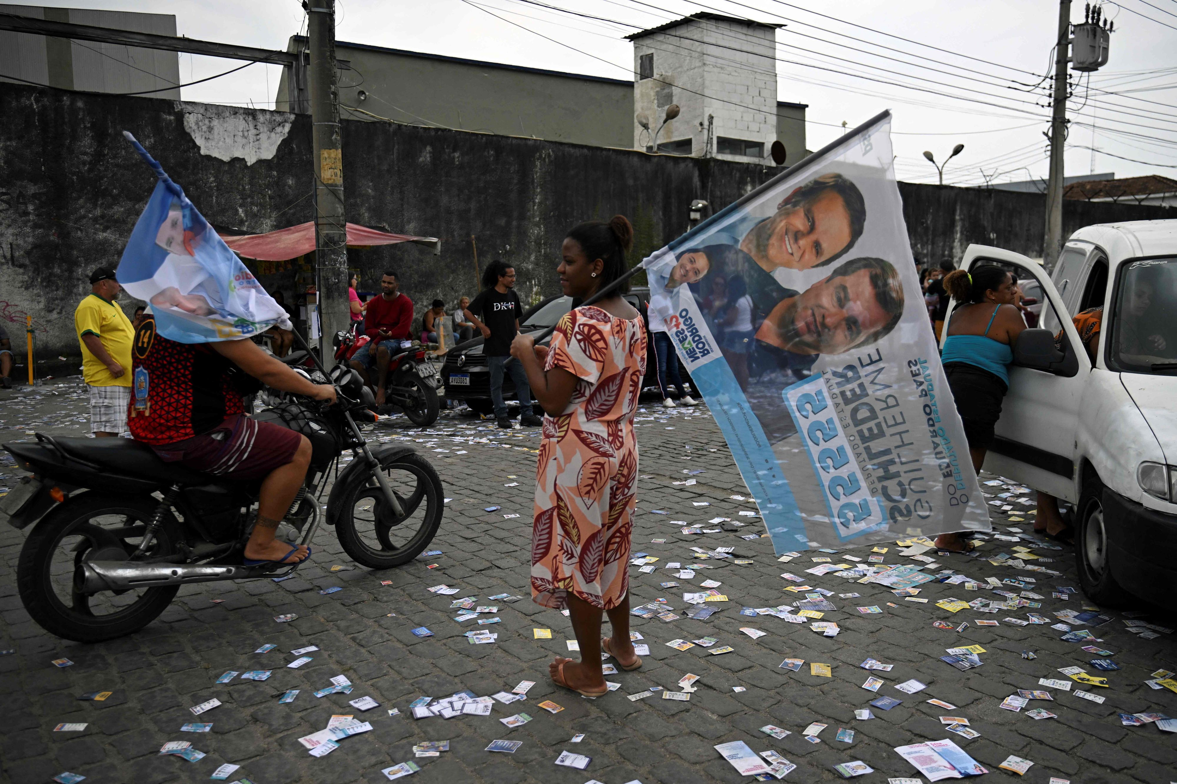 Download von www.picturedesk.com am 02.10.2022 (21:06).  A woman stands in the street during the legislative and presidential election, in Mare favela, in Rio de Janeiro, Brazil, on October 2, 2022. - Voting began early Sunday in South America's biggest economy, plagued by gaping inequalities and violence, where voters ar expected to choose between far-right incumbent Jair Bolsonaro and leftist front-runner Luiz Inacio Lula da Silva, any of which must garner 50 percent of valid votes, plus one, to win in the first round. (Photo by CARL DE SOUZA / AFP) - 20221002_PD9536 - Rechteinfo: Rights Managed (RM) Nur für redaktionelle Nutzung! Werbliche Nutzung erfordert Freigabe: bitte schicken Sie uns eine Anfrage.