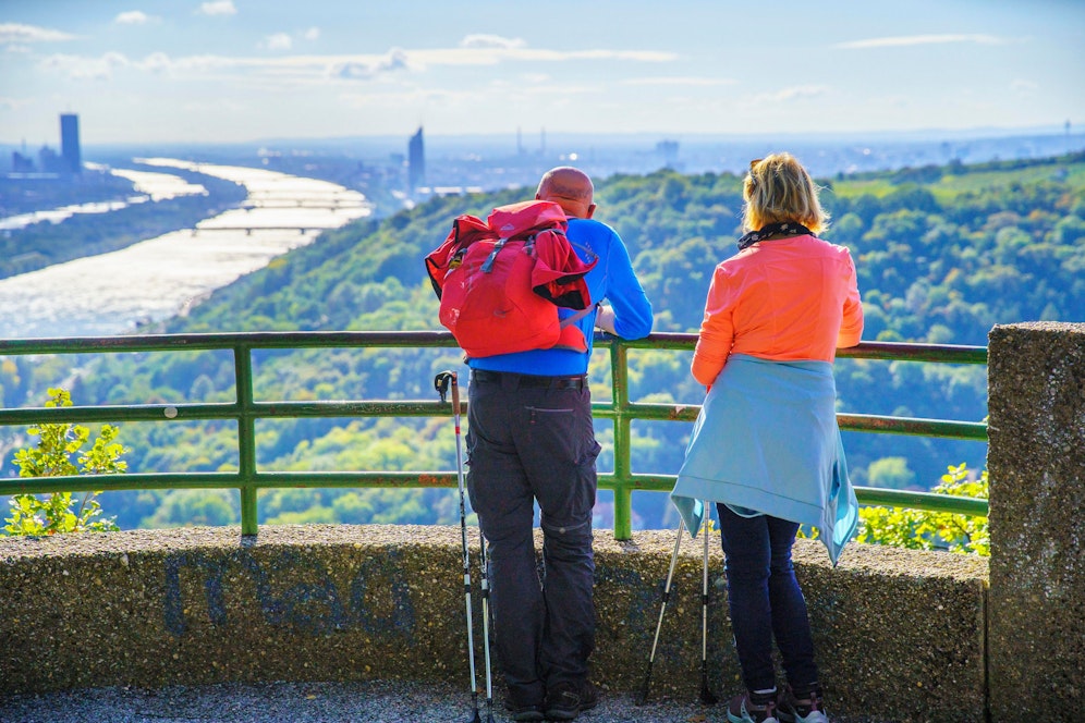 Ein Paar wandert am Nasenweg vom Kahlenbergerdorf auf den Leopoldsberg. Die Aussicht auf Wien ist spektakulär.