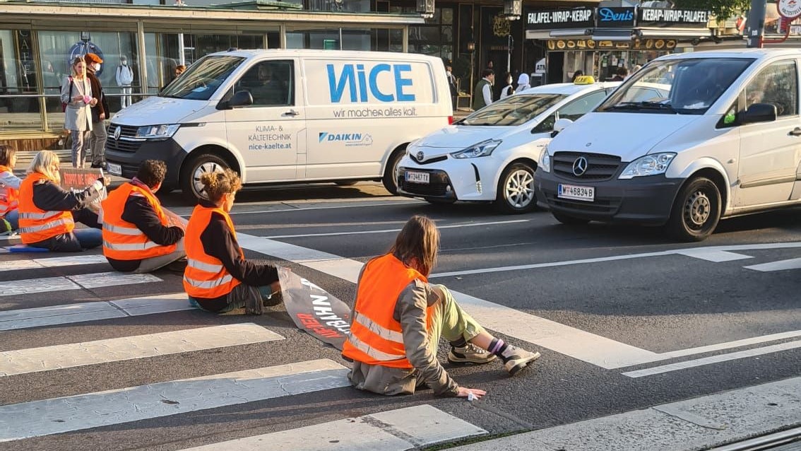 Am Opernring blockieren Klima-Aktivisten die Fahrbahn. 