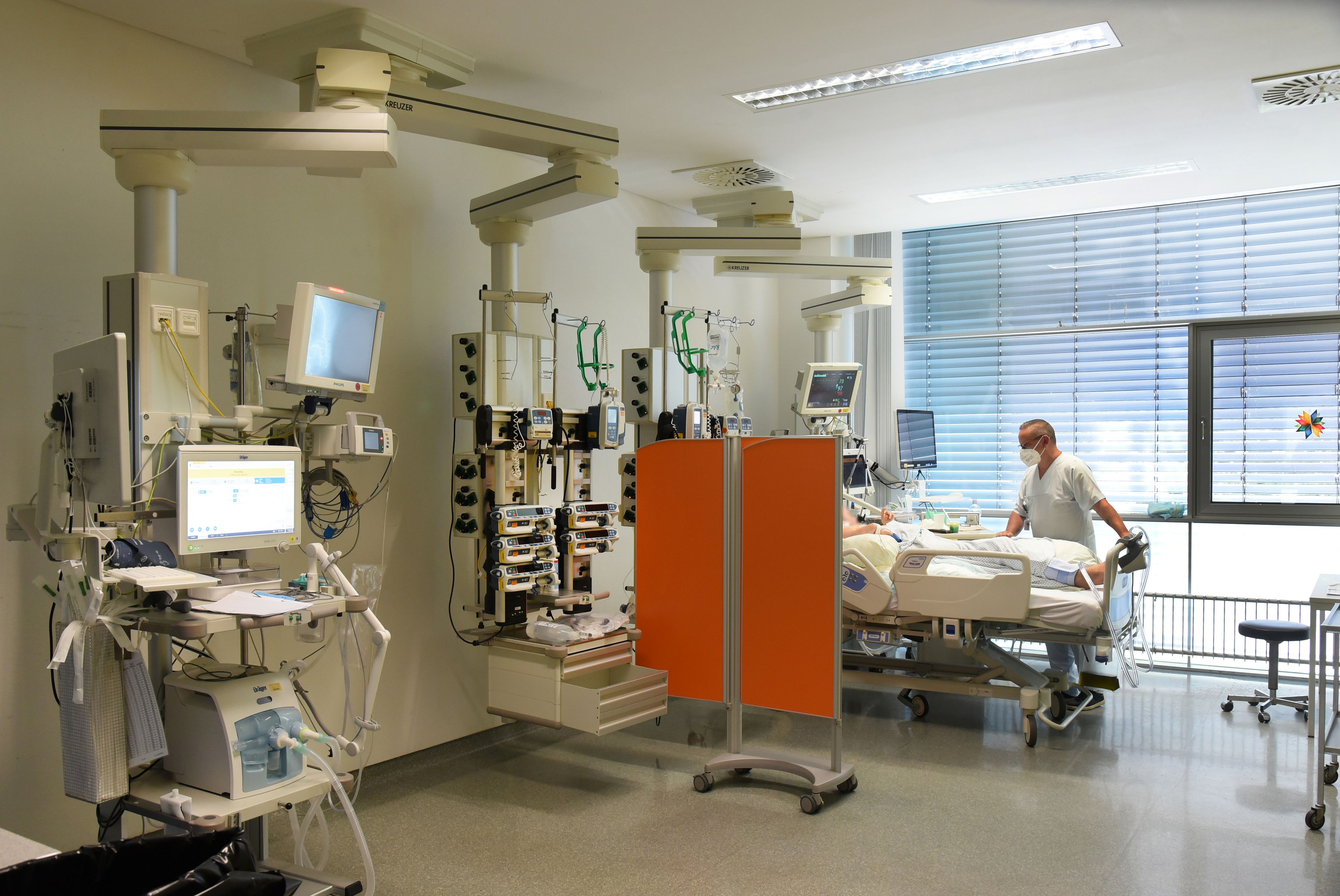Download von www.picturedesk.com am 31.10.2022 (14:44).  30 June 2022, Saxony, Leipzig: Ward manager Enrica Balder stands at a patient's bedside in the intensive care unit (ITS) at Klinikum St. Georg. The hospital is currently operating about a quarter fewer beds than in the pre-Corona era. The reason is staff shortage and the introduction of the nursing staff floors, said a spokeswoman. In addition, there are repeated absences due to staff suffering from covid. Especially in the intensive care areas and during operations, the shortage affects the ability to act. (to dpa "Situation in Saxon hospitals is tense") Photo: Waltraud Grubitzsch/dpa-Zentralbild/dpa - 20220630_PD17446 - Rechteinfo: Rights Managed (RM)