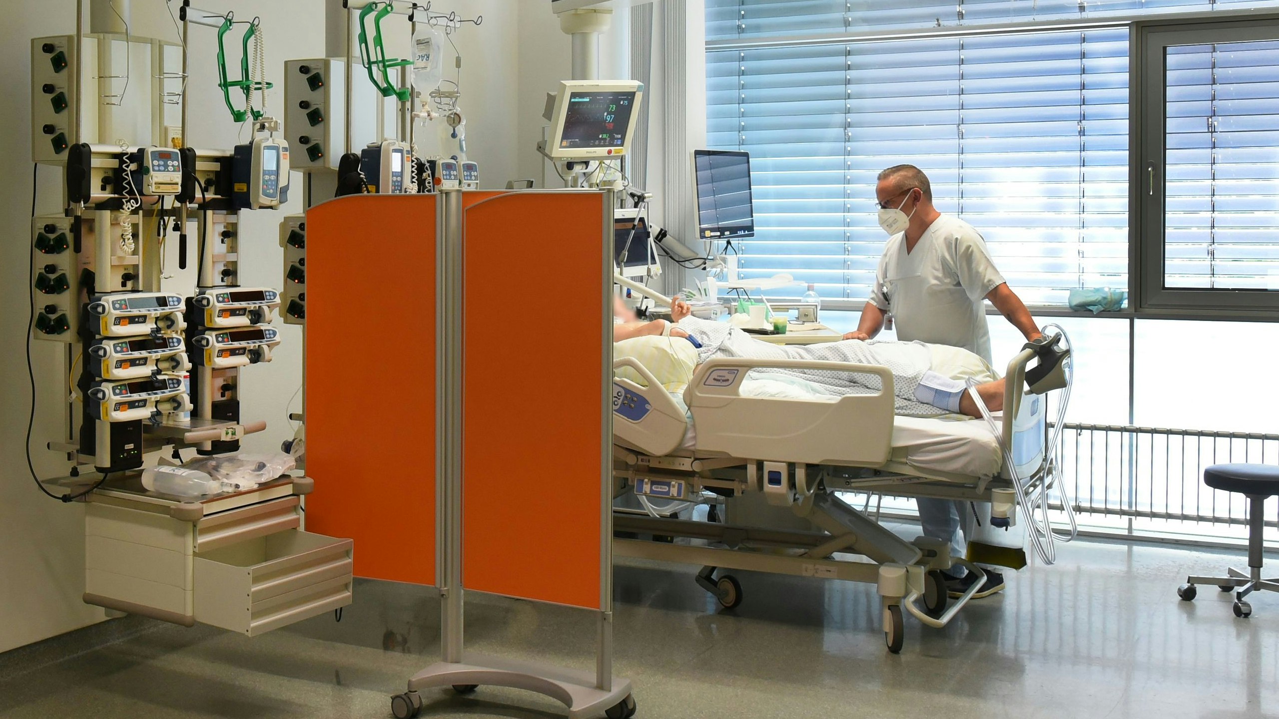 Download von www.picturedesk.com am 31.10.2022 (14:44).  30 June 2022, Saxony, Leipzig: Ward manager Enrica Balder stands at a patient's bedside in the intensive care unit (ITS) at Klinikum St. Georg. The hospital is currently operating about a quarter fewer beds than in the pre-Corona era. The reason is staff shortage and the introduction of the nursing staff floors, said a spokeswoman. In addition, there are repeated absences due to staff suffering from covid. Especially in the intensive care areas and during operations, the shortage affects the ability to act. (to dpa "Situation in Saxon hospitals is tense") Photo: Waltraud Grubitzsch/dpa-Zentralbild/dpa - 20220630_PD17446 - Rechteinfo: Rights Managed (RM)