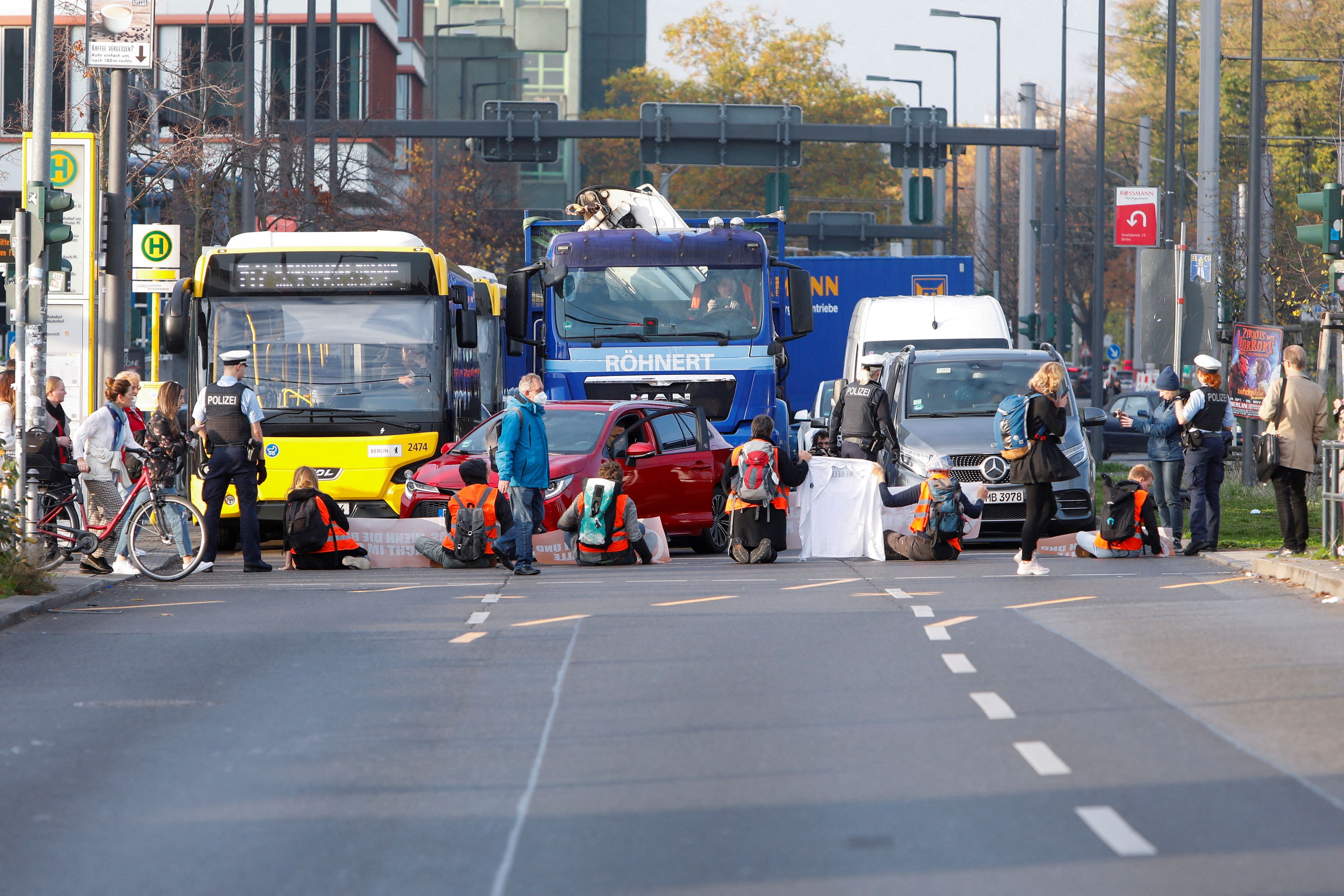 FILE PHOTO: Pedestrians cross the street as climate activists block its traffic lanes in Berlin, Germany October 31, 2022. REUTERS/Michele Tantussi/File Photo