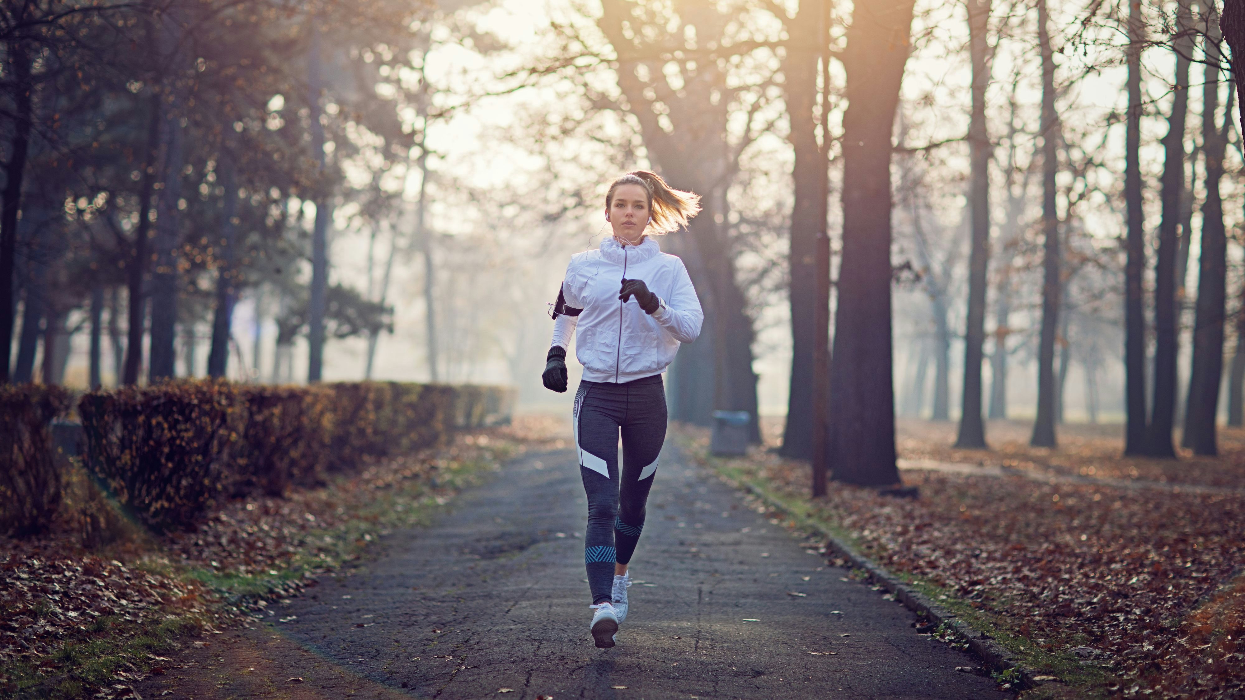 Young woman is running in the cold foggy morning