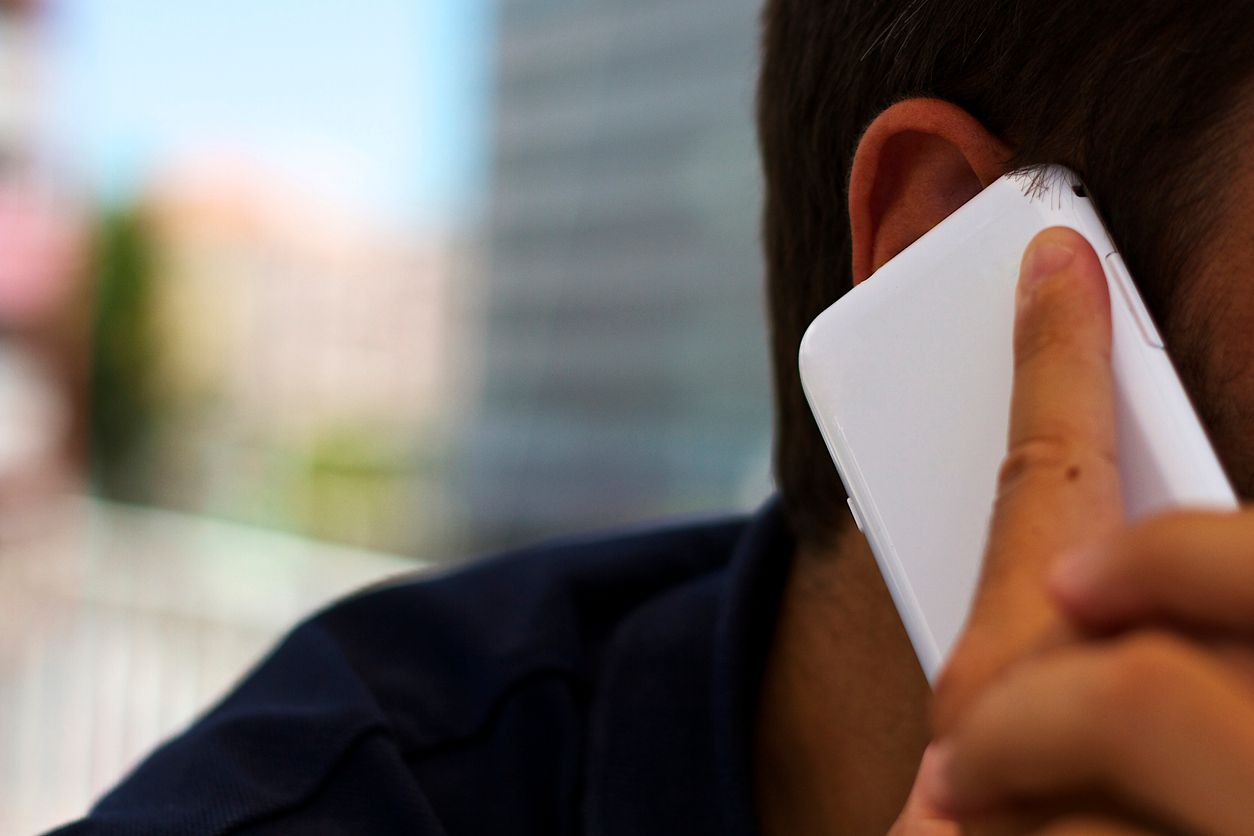 man holding the phone next to the ear.
