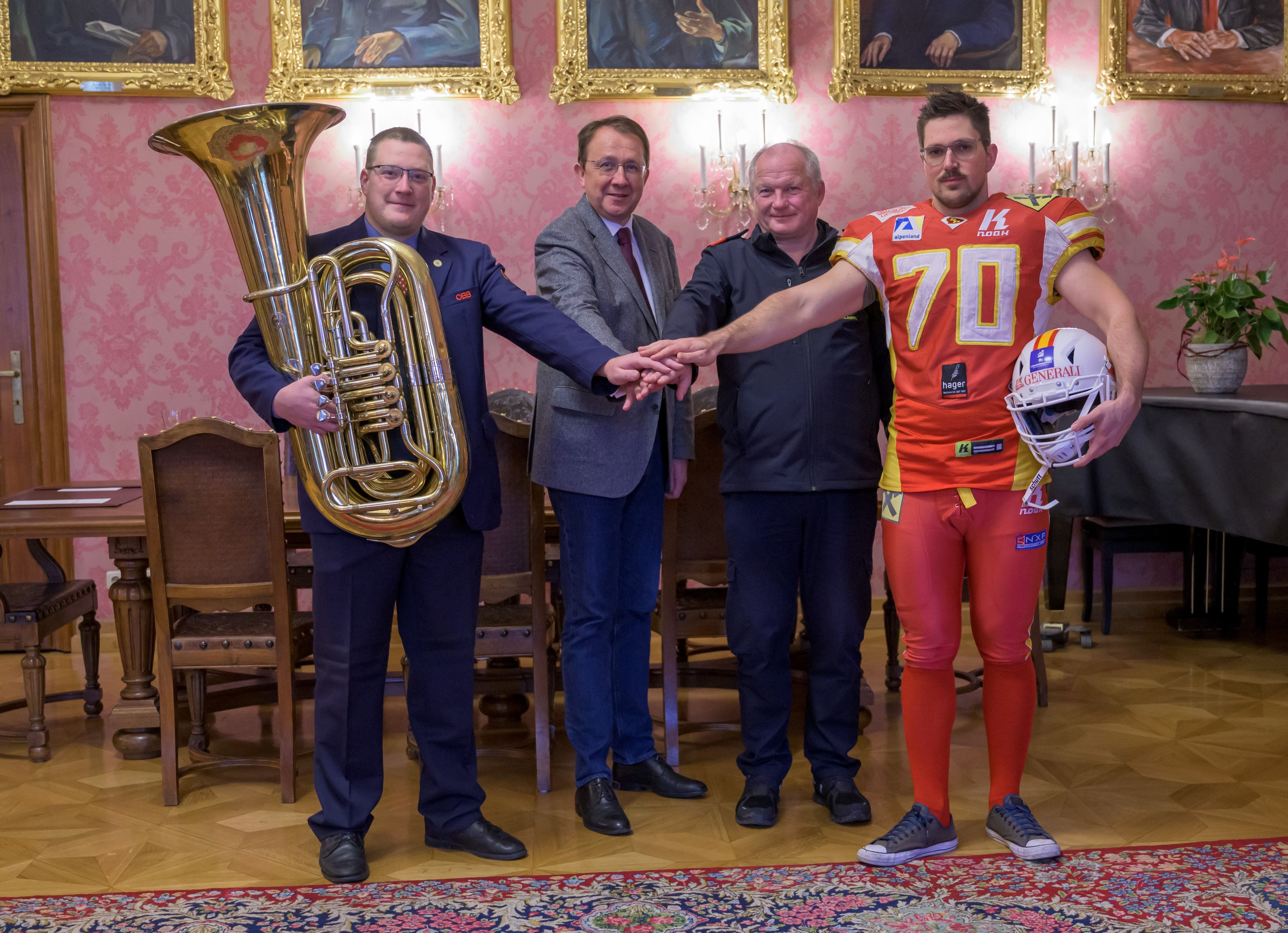 Bürgermeister Matthias Stadler, Lukas Halbartschlager von Eisenbahner-Blasmusik, Abschnittsfeuerwehrkommandant Franz Klampfl und Footballspieler MIchael Derfler von Generali Invaders kämpfen Hand in Hand für Aufklärungsarbeit zum Impfstatus.