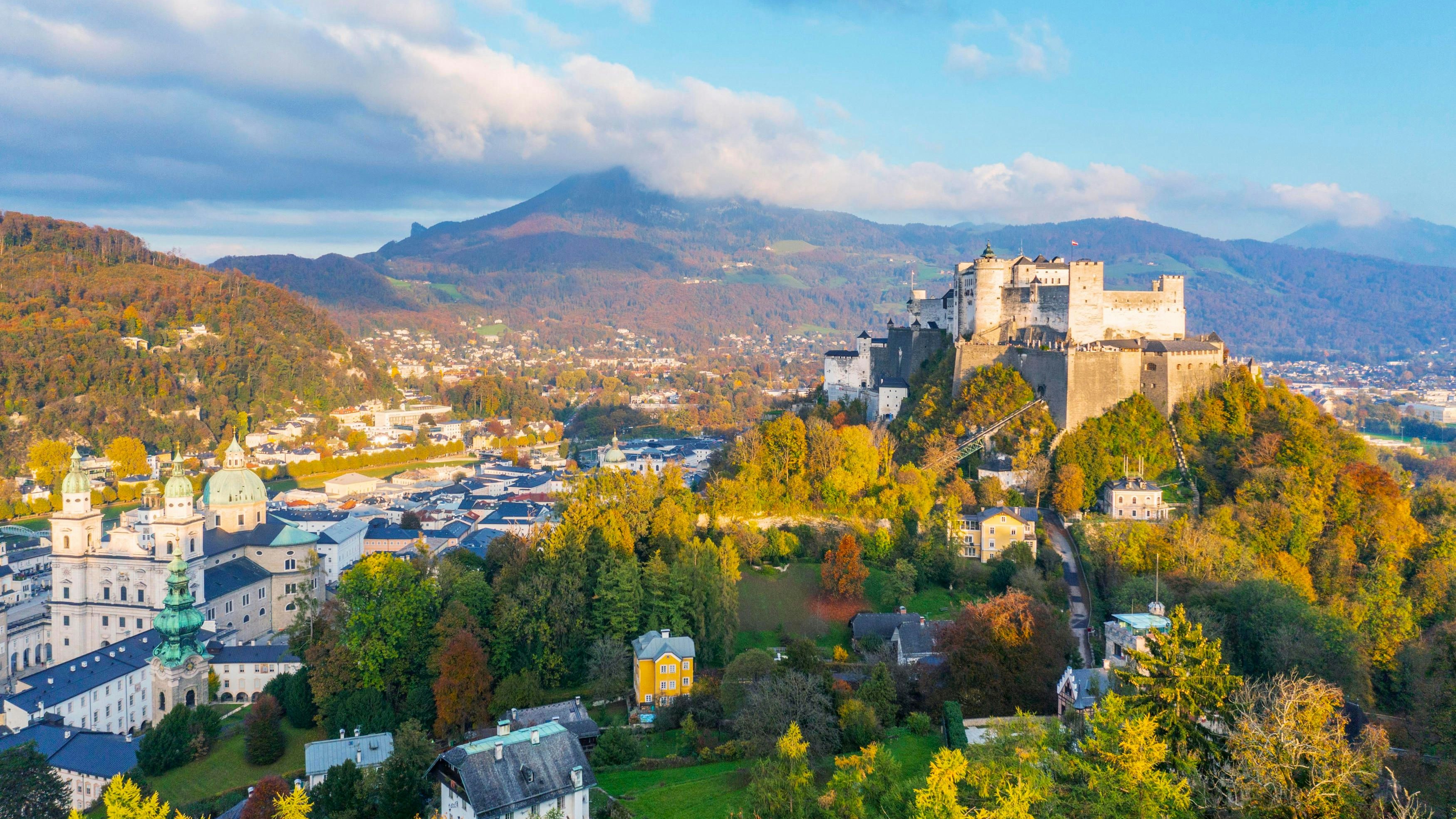 Download von www.picturedesk.com am 17.11.2022 (19:02).  Blick an einem Herbstabend vom Mönchsberg über herbstliche Bäume nahe dem Freyschlössl hinunter auf die Salzburger Altstadt mit dem Dom, Stift St. Peter, Franziskanerkirchem darüber die Festung Hohenssalzburg und weiter über die Salzach zum Kapuzinerberg mit herbstlich bunten Bäumen und zum Gaisberg - 20221019_PD16731 - Rechteinfo: Rights Managed (RM)