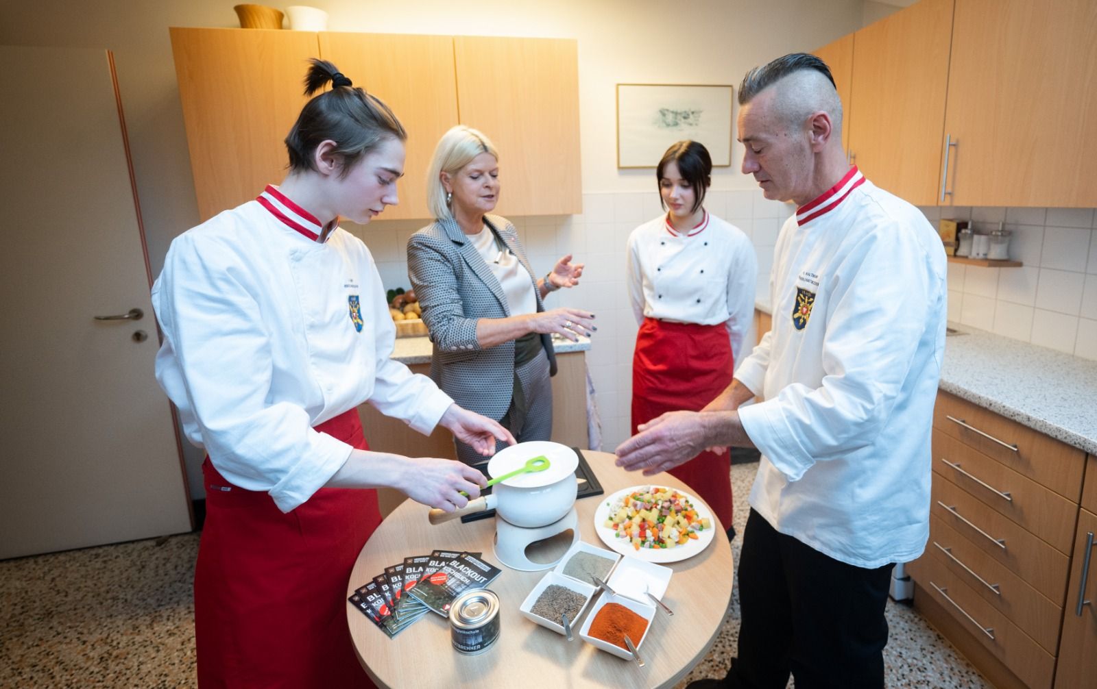 Verteidigungsministerin Klaudia Tanner mit dem Personal der Lehr- und Versuchsküche der Heereslogistikschule in Wien, die das Blackout-Kochbuch entwickelt hat.