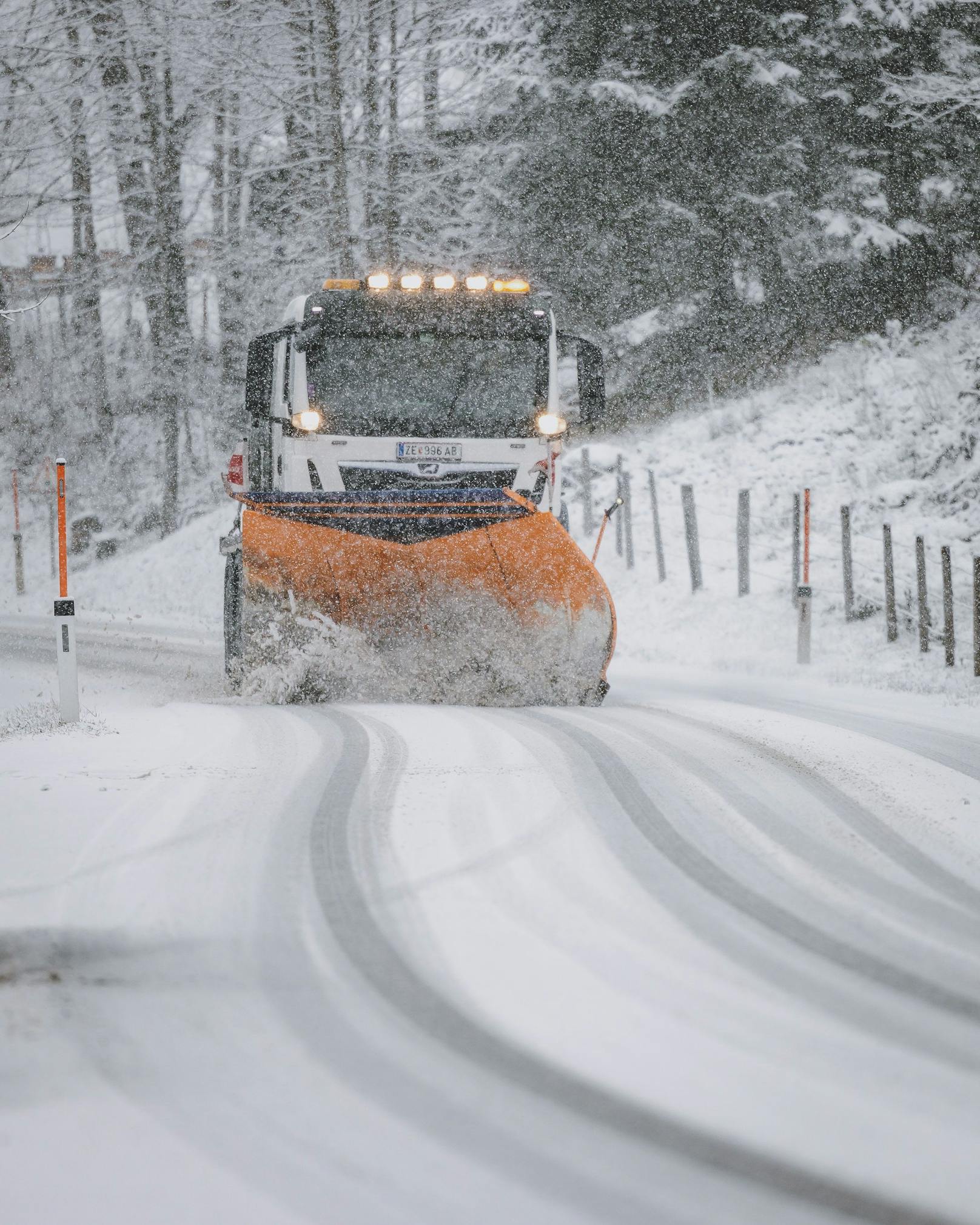 Fahrzeug des Winterdienstes bei der Räumung der mit Schnee bedeckten Fahrbahn, aufgenommen am 22. November 2022 in Kaprun.