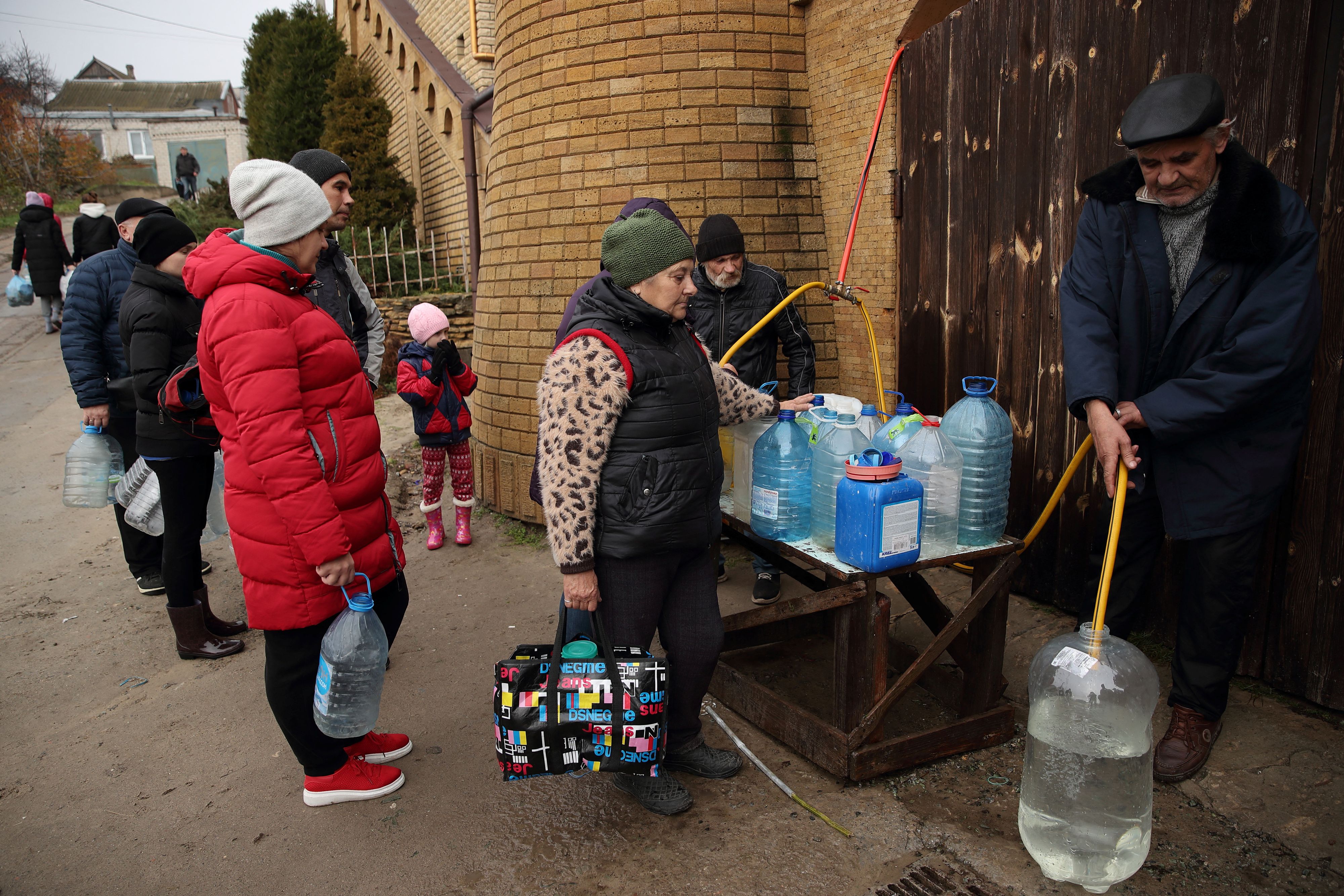 People fill up bottles with water near Dnipro river after Russia's military retreat from Kherson, Ukraine November 21, 2022. REUTERS/Murad Sezer