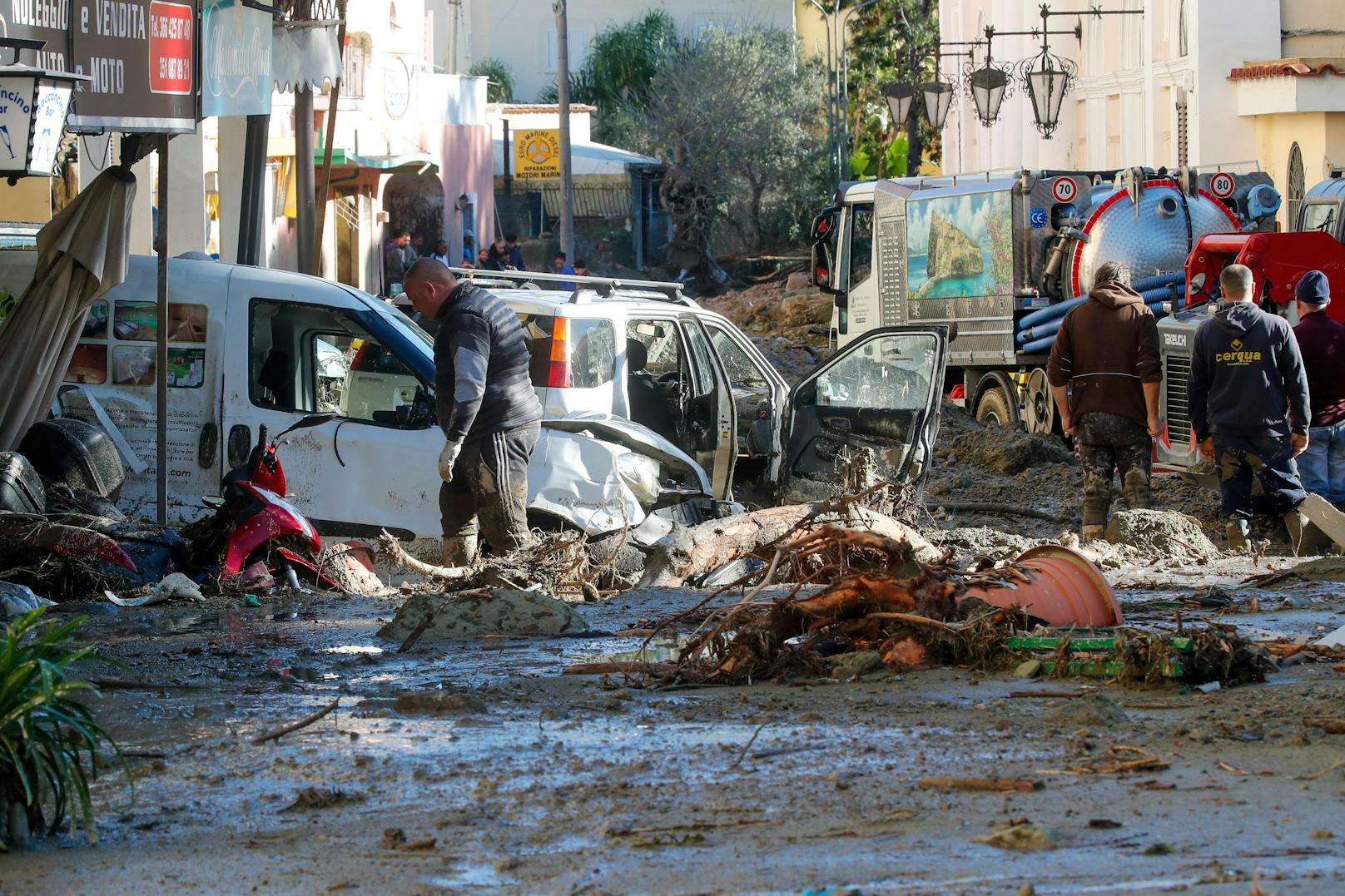 Menschen entfernen Schlamm und Trümmer, nachdem starke Regenfälle Erdrutsche ausgelöst hatten, die Gebäude zum Einsturz brachten, in Casamicciola auf der süditalienischen Insel Ischia.