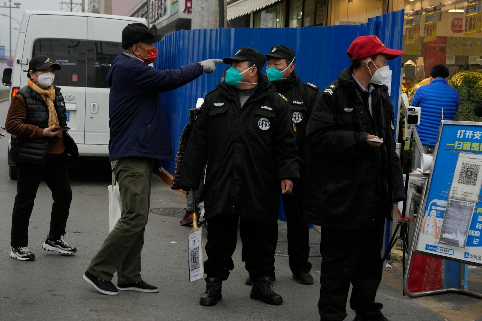 Sicherheitskräfte kontrollieren den Zugang zu einer abgeriegelten Gemeinde in Peking. China weitet die Lockdowns aus, auch in einer zentralen Stadt, in der Fabrikarbeiter diese Woche mit der Polizei zusammenstießen, da die Zahl der COVID-19-Fälle einen Tagesrekord erreichte.