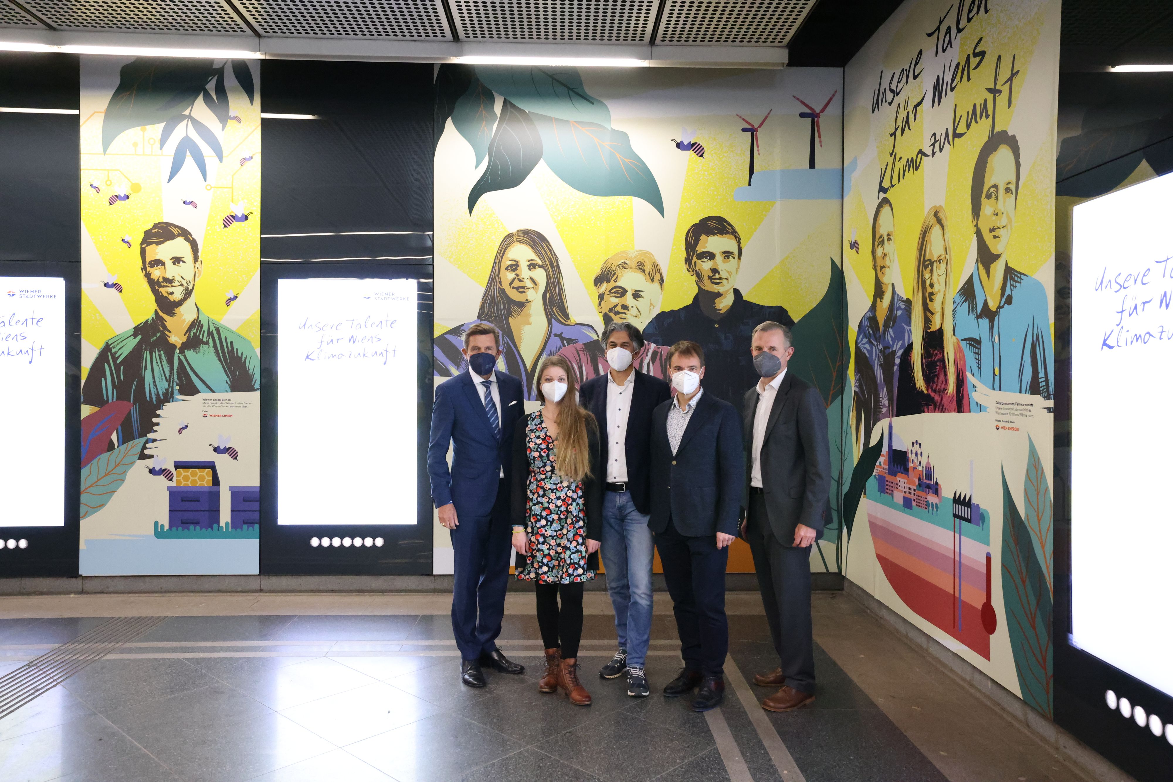 Stadtrat Peter Hanke (SPÖ), die drei Preisträger und Peter Weinelt, stellvertretender Geschäftsführer der Stadtwerke (v.l.) vor dem Wandbild von Street-Artist Emanuel Jesse – er hat die Preisträger im U-Bahnhof Stephansplatz als ein Mural (Wandbild) 