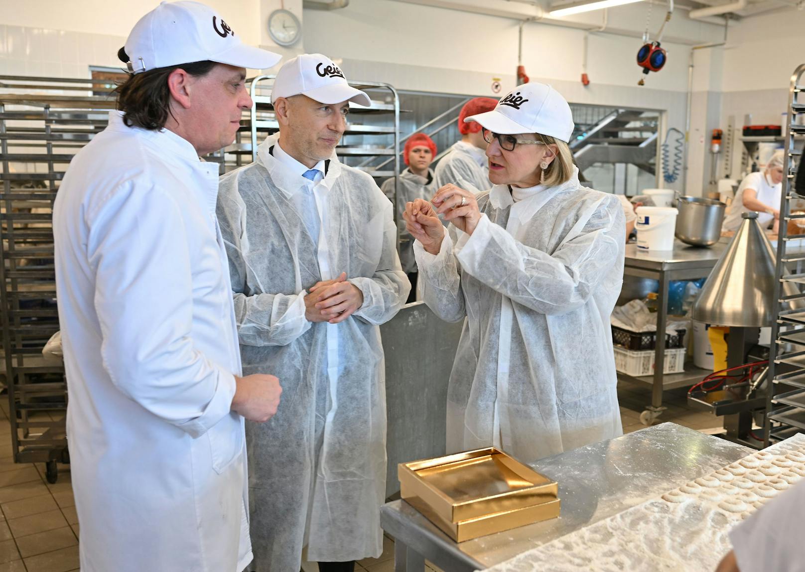 Landeshauptfrau Johanna Mikl-Leitner, Bundesminister Martin Kocher und Gerald Geier im Gespräch während der Betriebsführung durch die Produktionsstätte der Bäckerei Geier in Markgrafneusiedl.