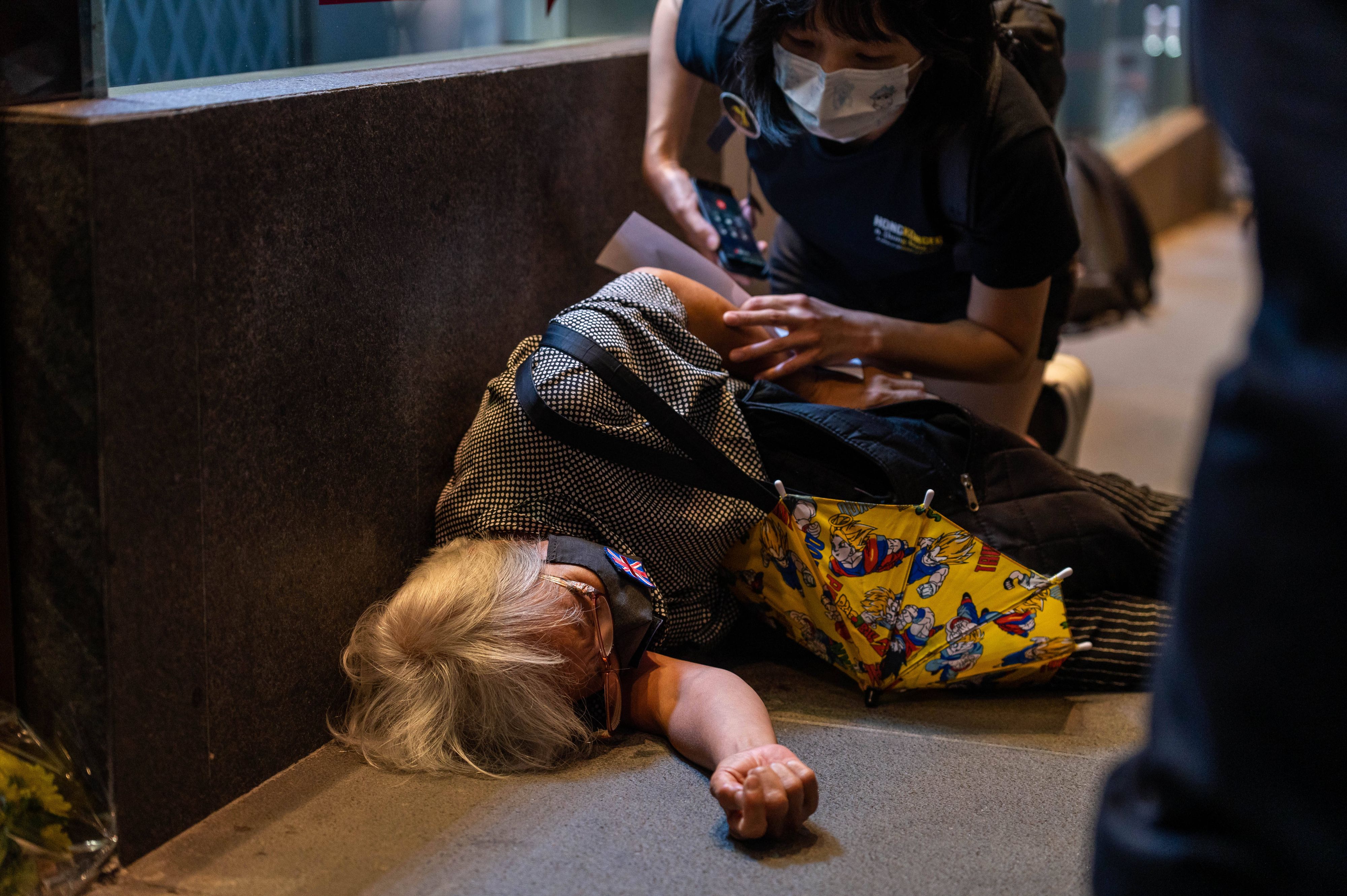 Kurz nachdem diese Frau "Will keinen Autoritarismus, will keine Monarchie" gerufen hatte, wurde sie von einem Angreifer zu Boden gestoßen.