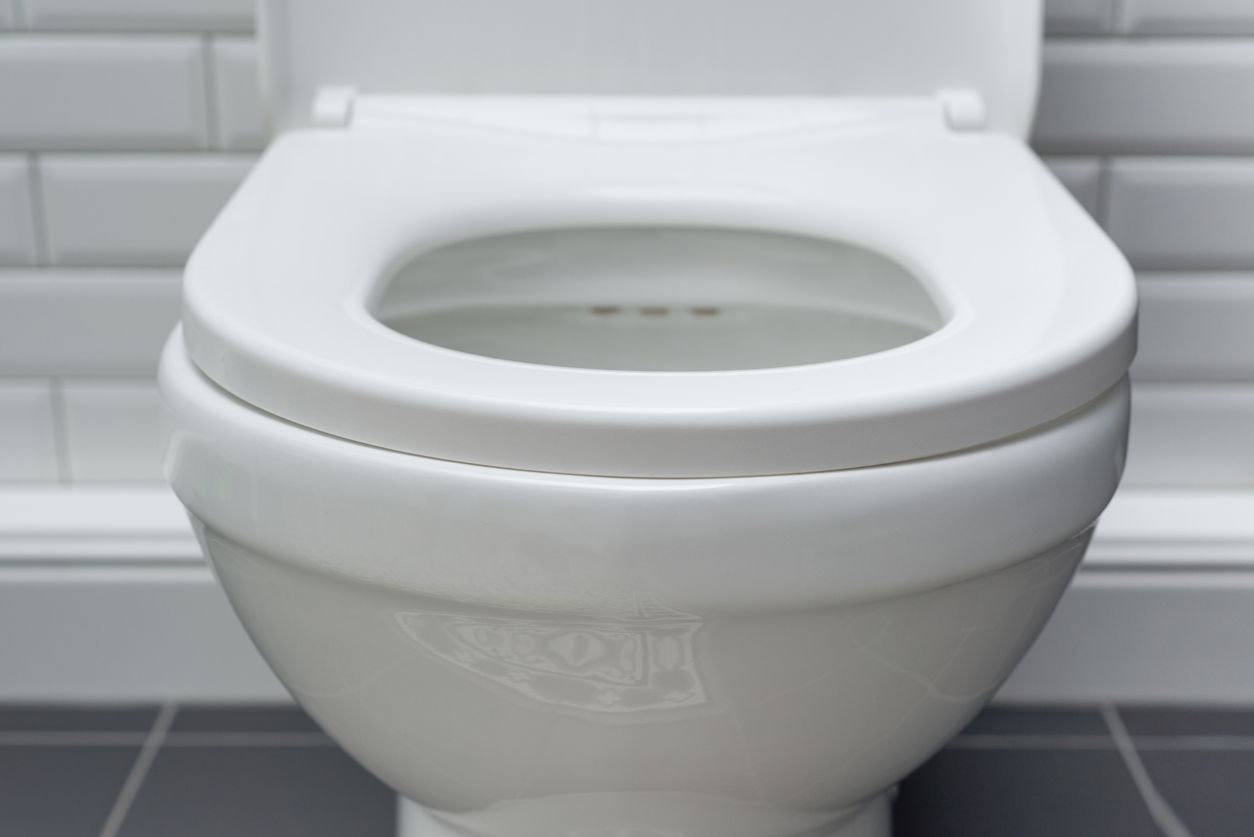 White ceramic toilet bowl in the bathroom interior close-up.