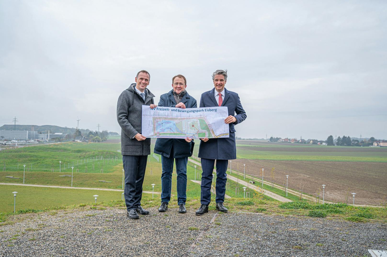 Bürgermeister Matthias Stadler (M.), NV-Generaldirektor Stefan Jauk und Sportlandesrat Jochen Danninger (l.) präsentieren die Pläne für den neuen Freizeit- und Bewegungspark beim Eisberg.