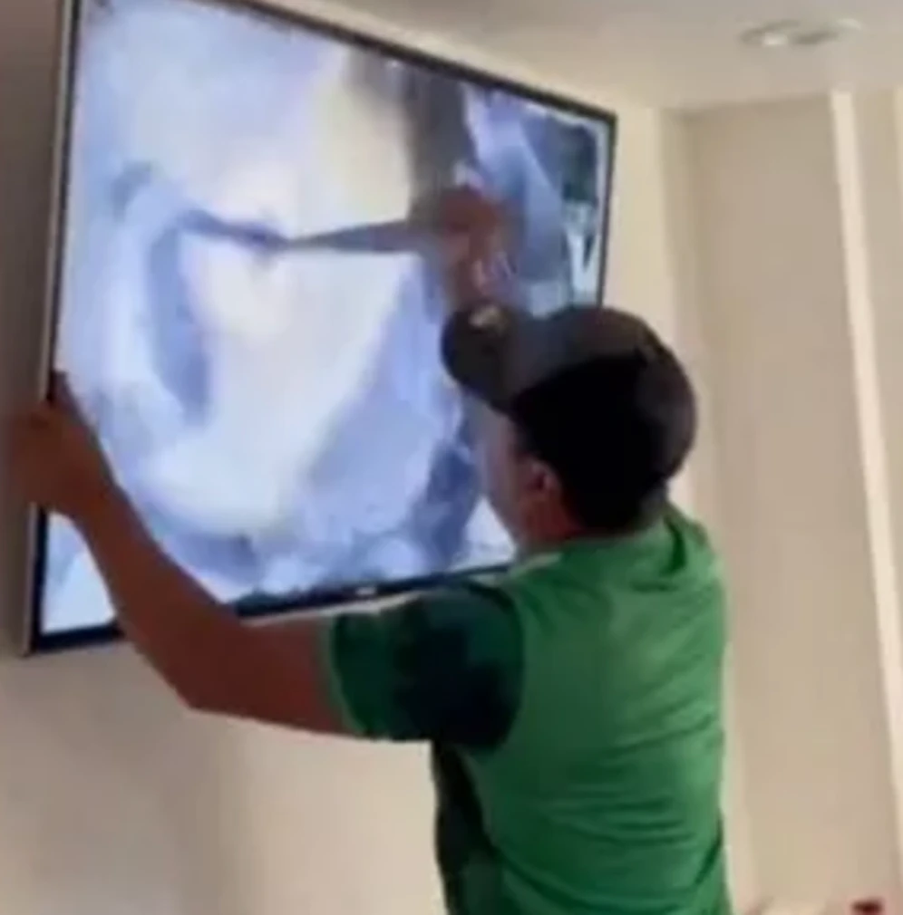 Dieser Fan sticht auf seinen eigenen Fernseher ein.