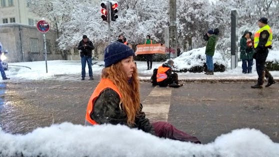 Zwei Aktivisten klebten sich in grauslichen Schneematsch auf die Straße. Die Mitte blieb für Rettungsfahrzeuge frei.