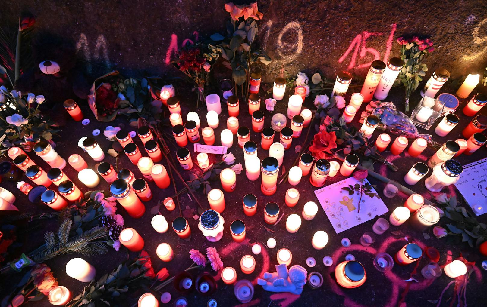 Kerzen und Blumen stehen an einem Tatort, an dem am Vortag zwei Mädchen von einem Mann mit einem Messer angegriffen wurden.