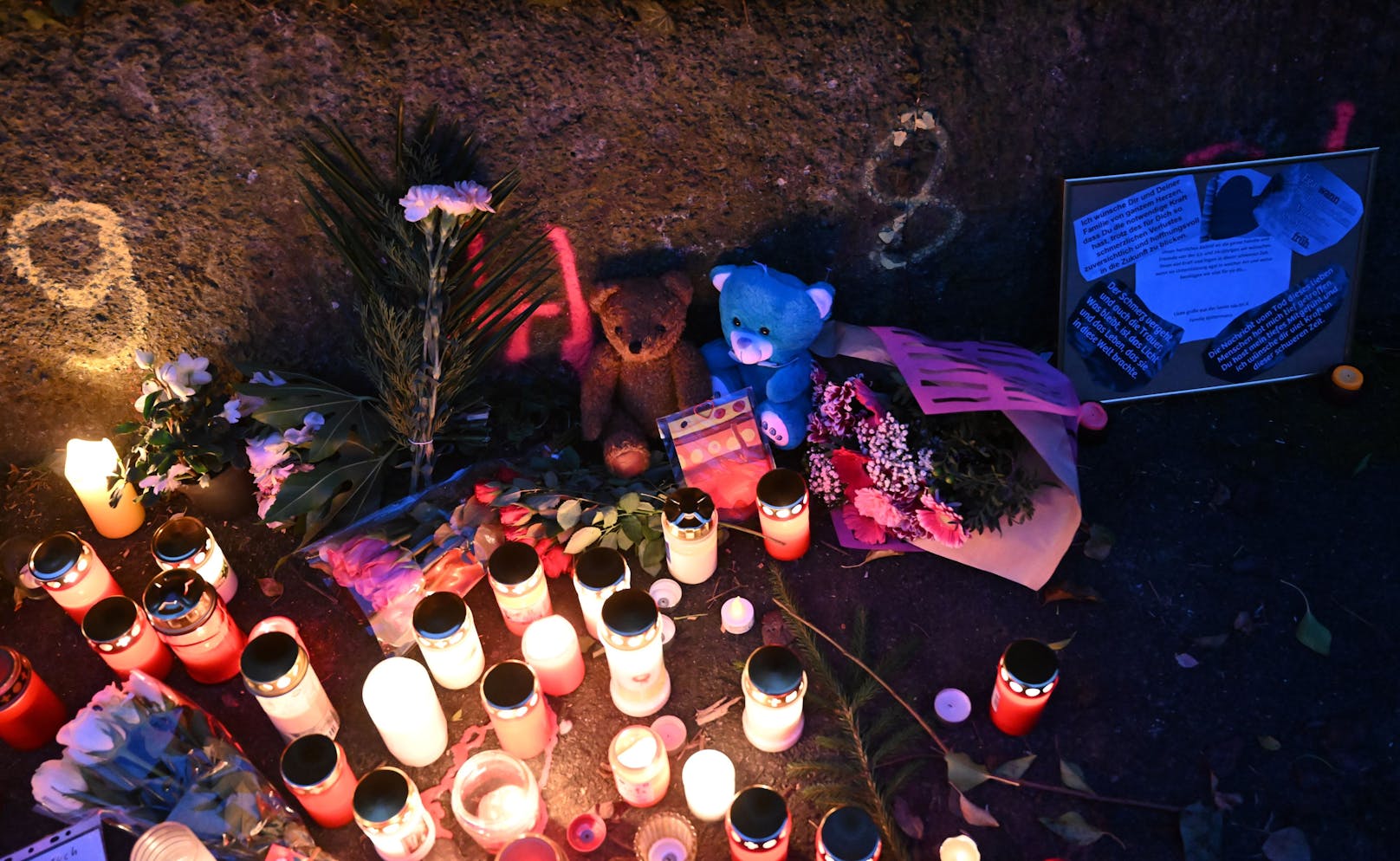 Kerzen und Blumen stehen an einem Tatort, an dem am Montag zwei Mädchen von einem Mann mit einem Messer angegriffen wurden.