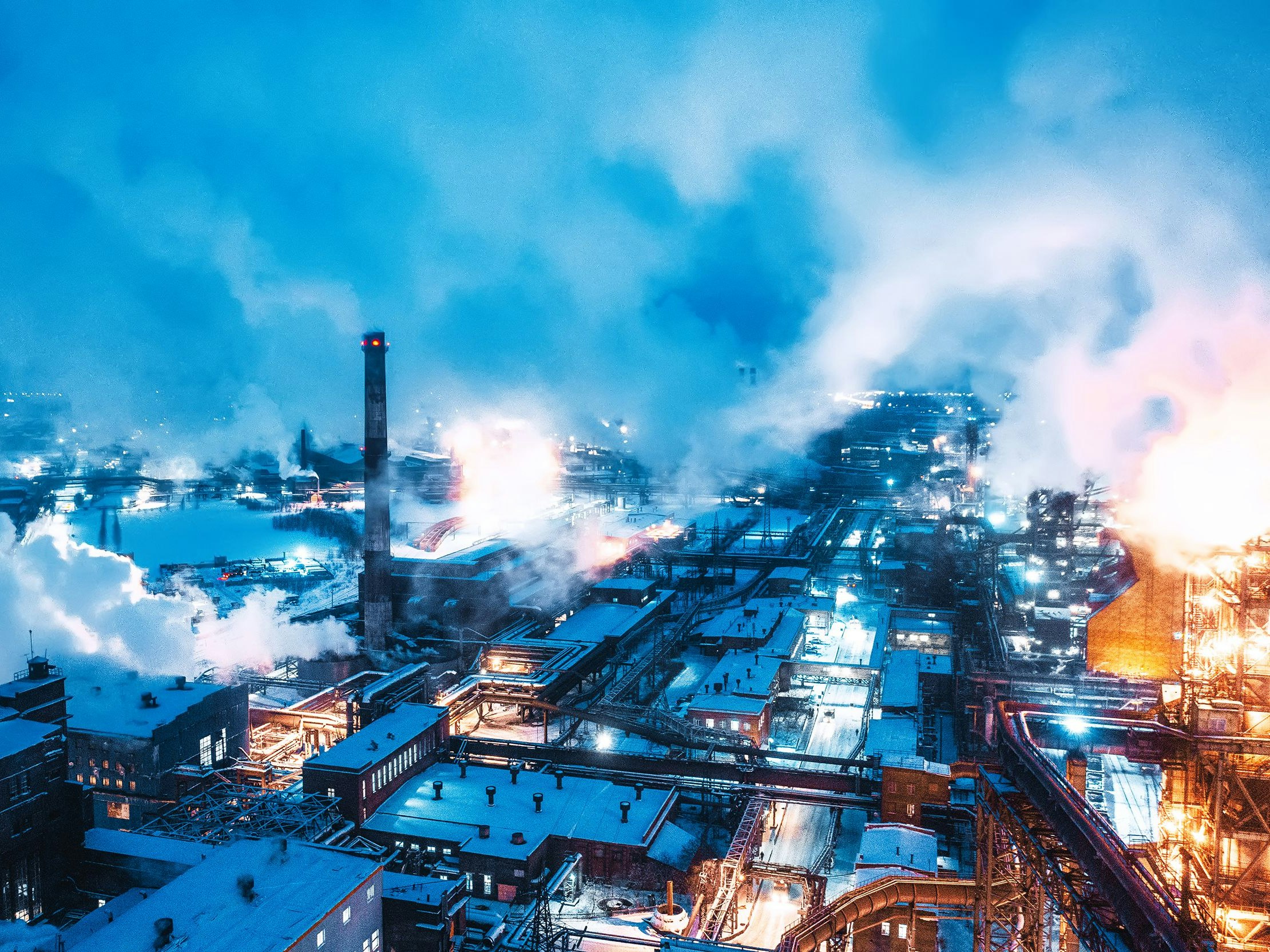 Top view of the night metallurgical plant. Smoke and fires of a blast furnace. Environmental pollution